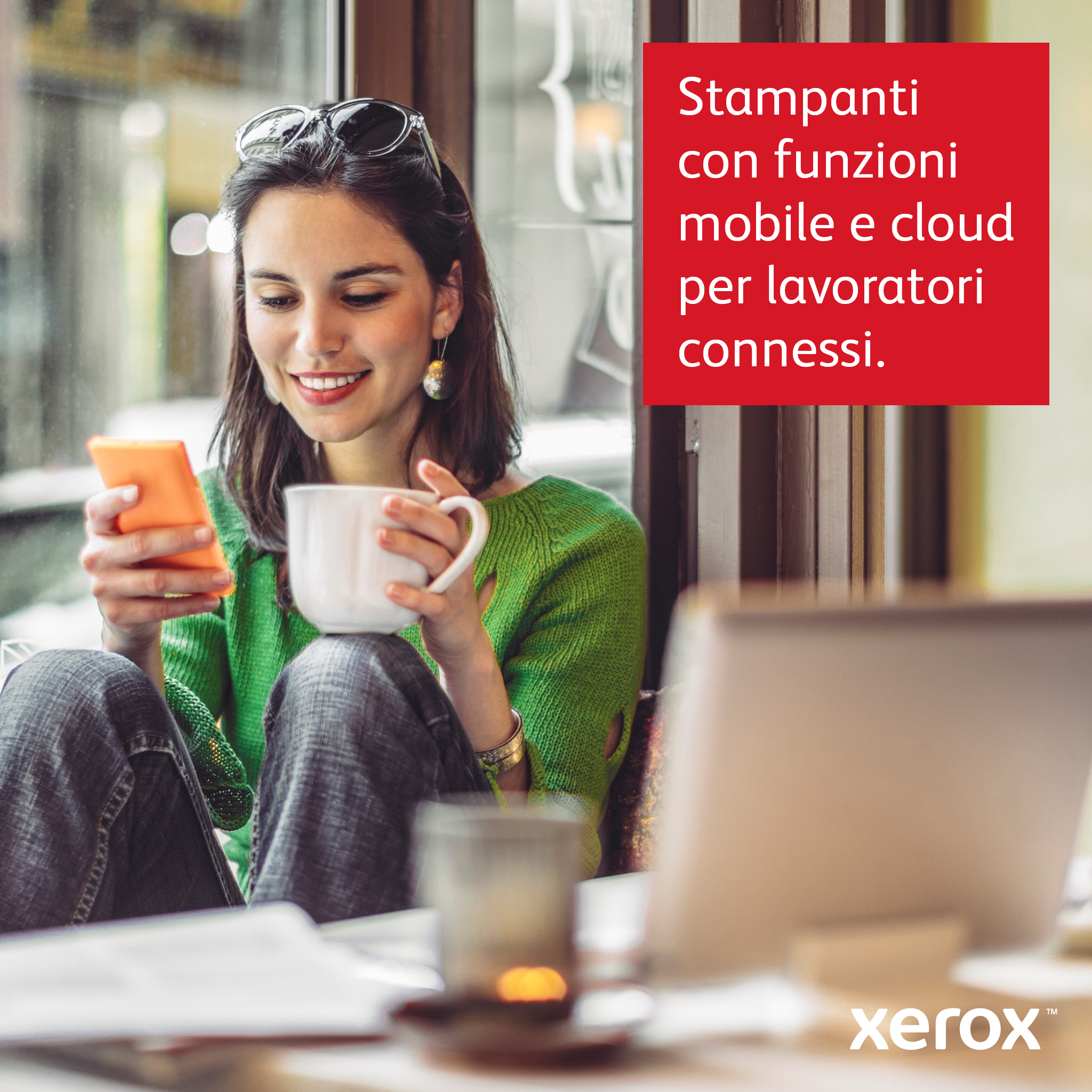 Mujer con suéter verde usando el teléfono, taza. Texto: Impresoras con funciones móviles y en la nube para trabajadores conectados.