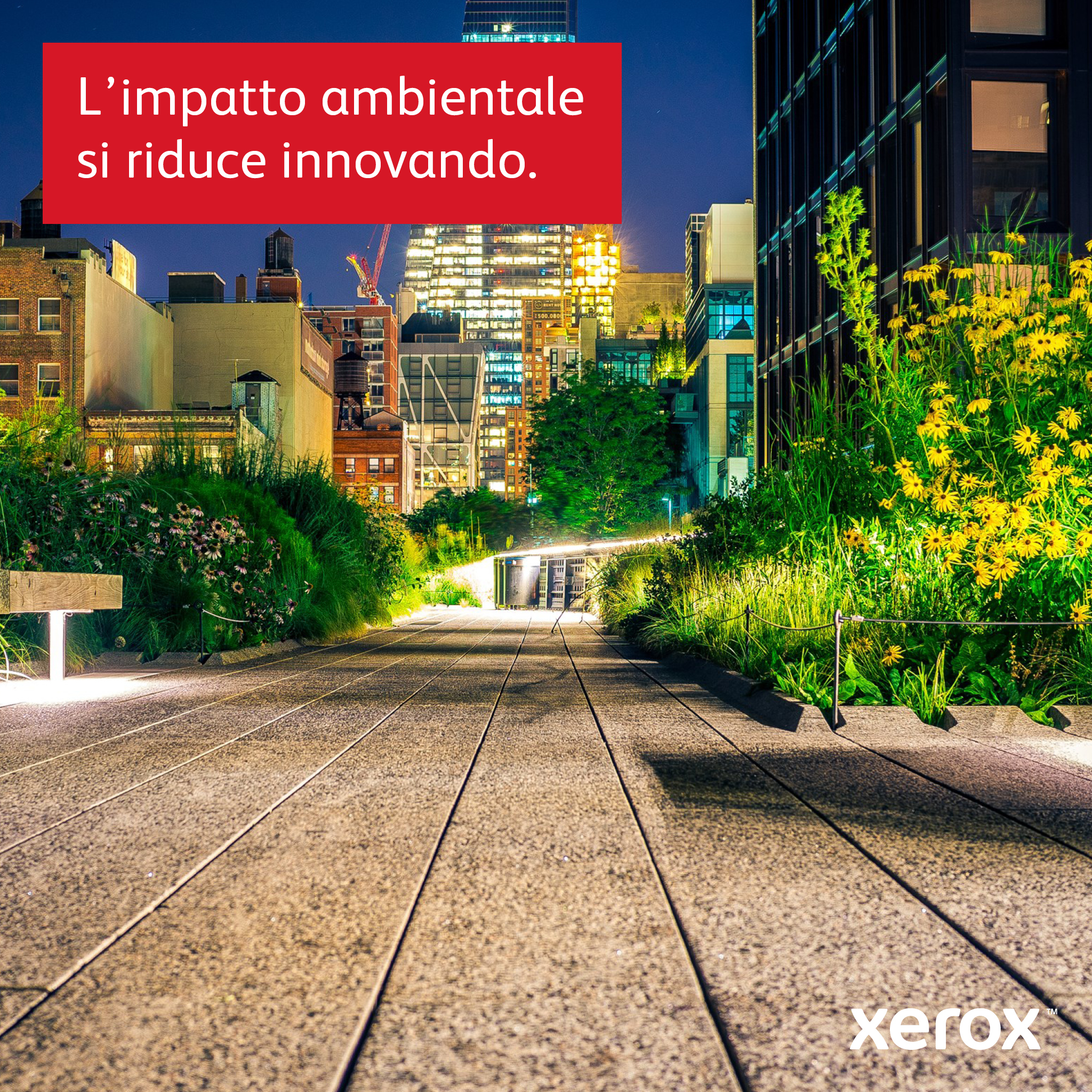 Paisaje urbano nocturno con luces y zonas verdes. Texto italiano: El impacto ambiental se reduce innovando.