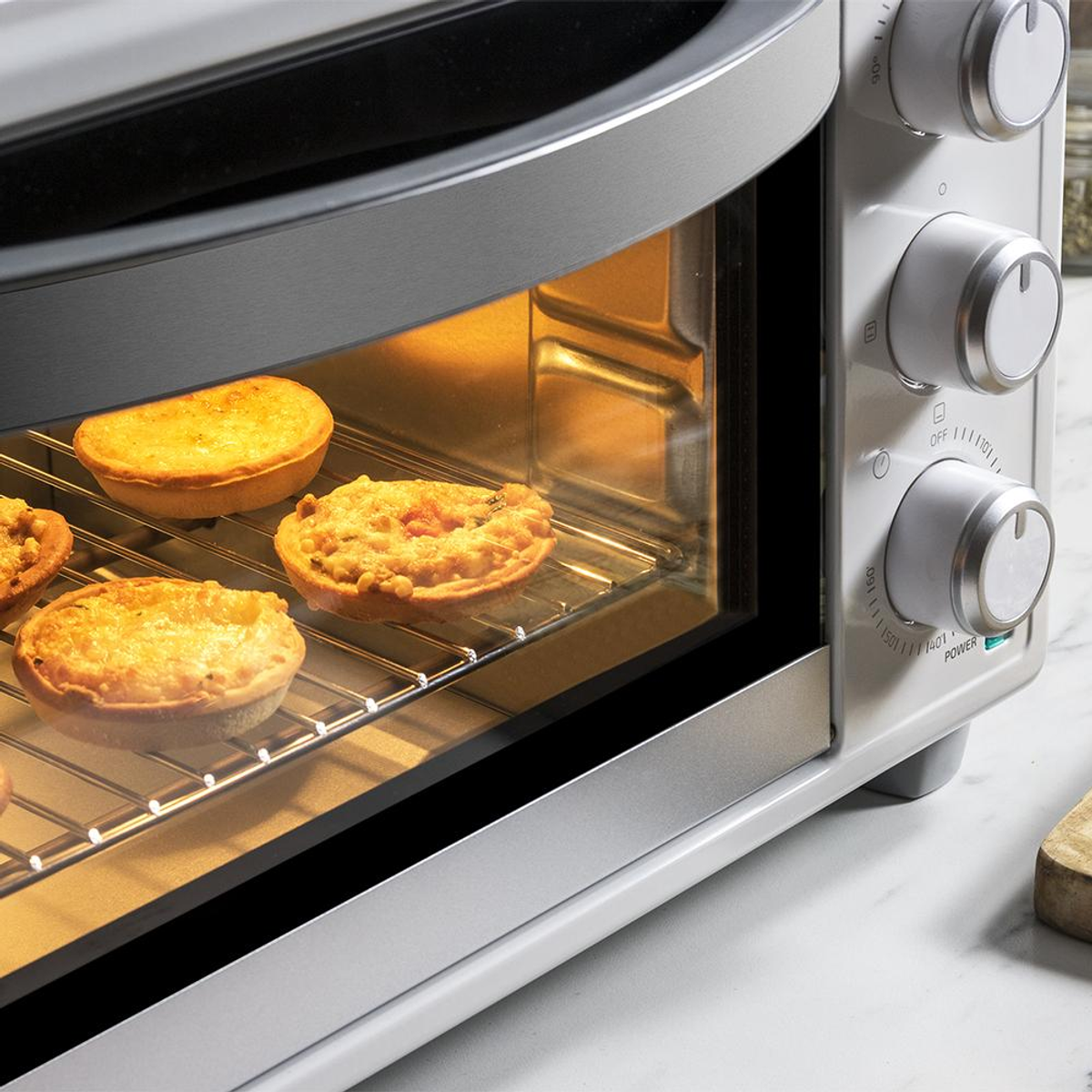 Piekarnik z piekącymi się tartami. Pokrętła po prawej stronie. Piekarnik jest srebrny.