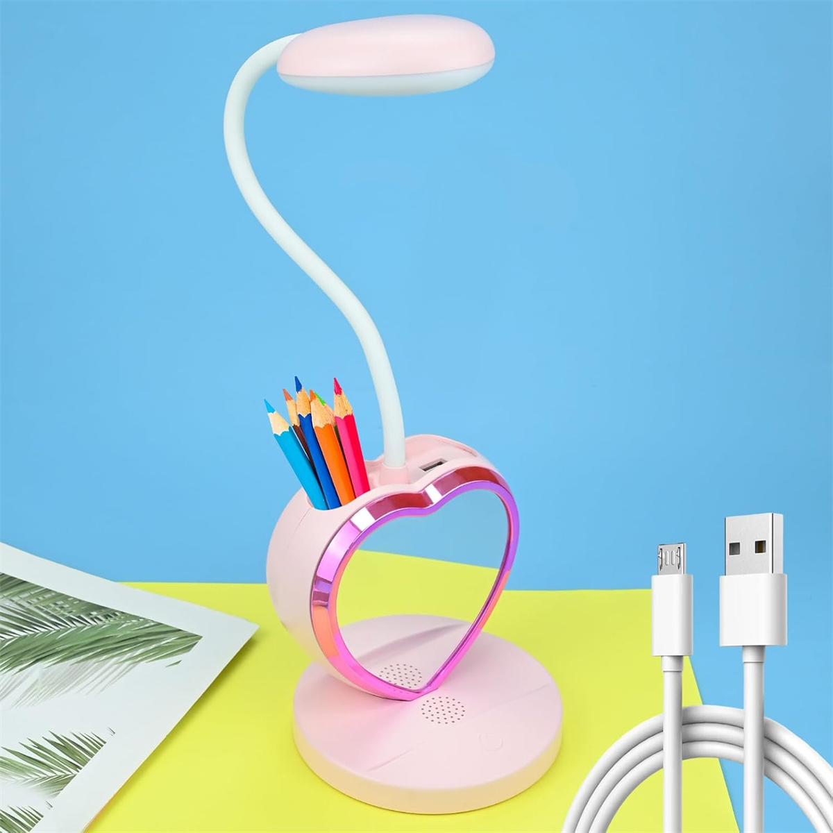 Rosa herzförmige Schreibtischlampe, Bleistifte und Ladekabel.
