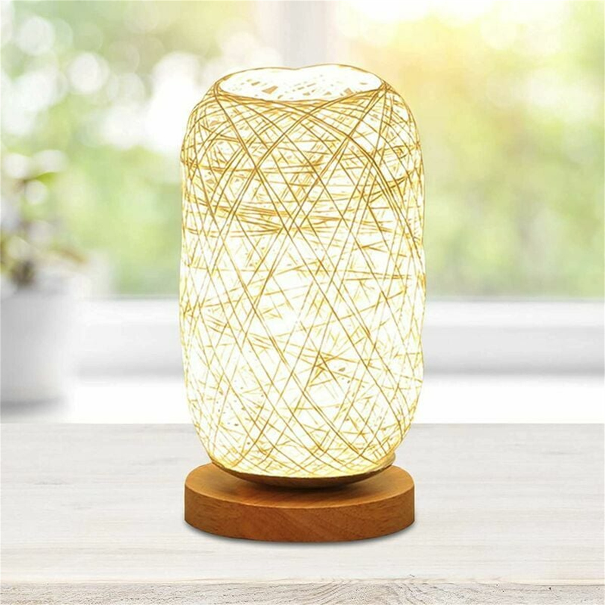 Eine Tischlampe mit Holzfuß und einem gewebten, zylindrischen Schirm mit warmem, leuchtendem Licht im Inneren.