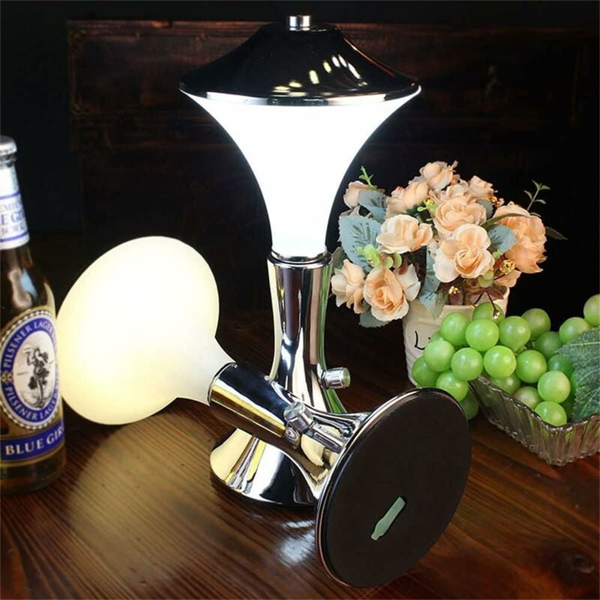 Eine Lampe mit einer Flasche Bier und Blumen.