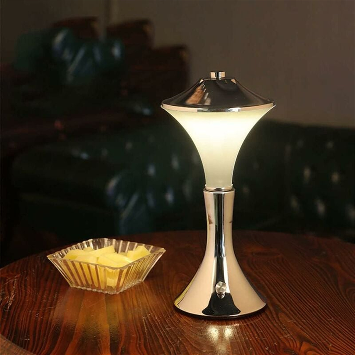 Eine silberne und weiße Lampe mit leuchtender Oberseite und eine Schüssel mit gelben Snacks.