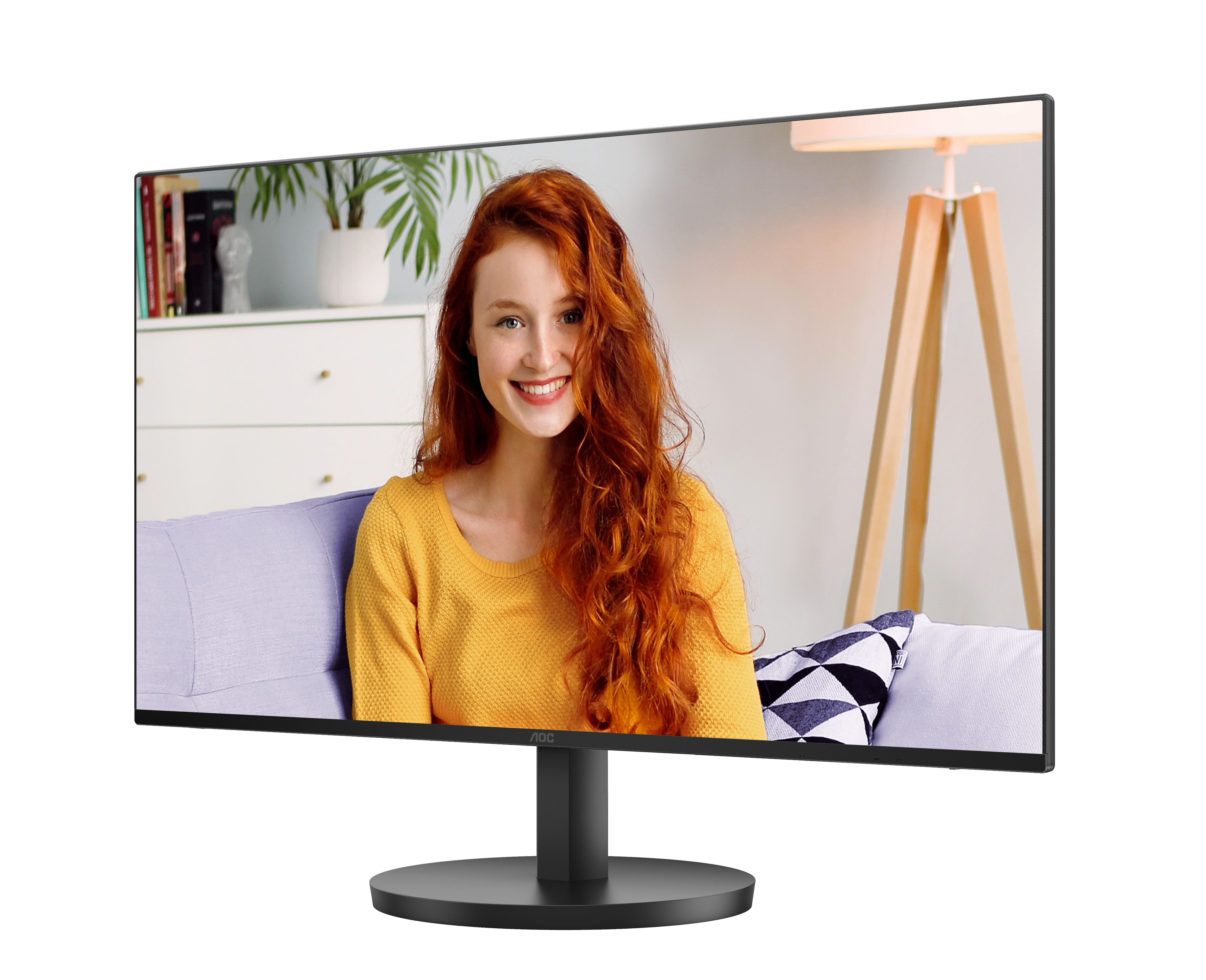 Een vrouw op een monitor glimlacht. Ze heeft rood haar en draagt een gele trui.