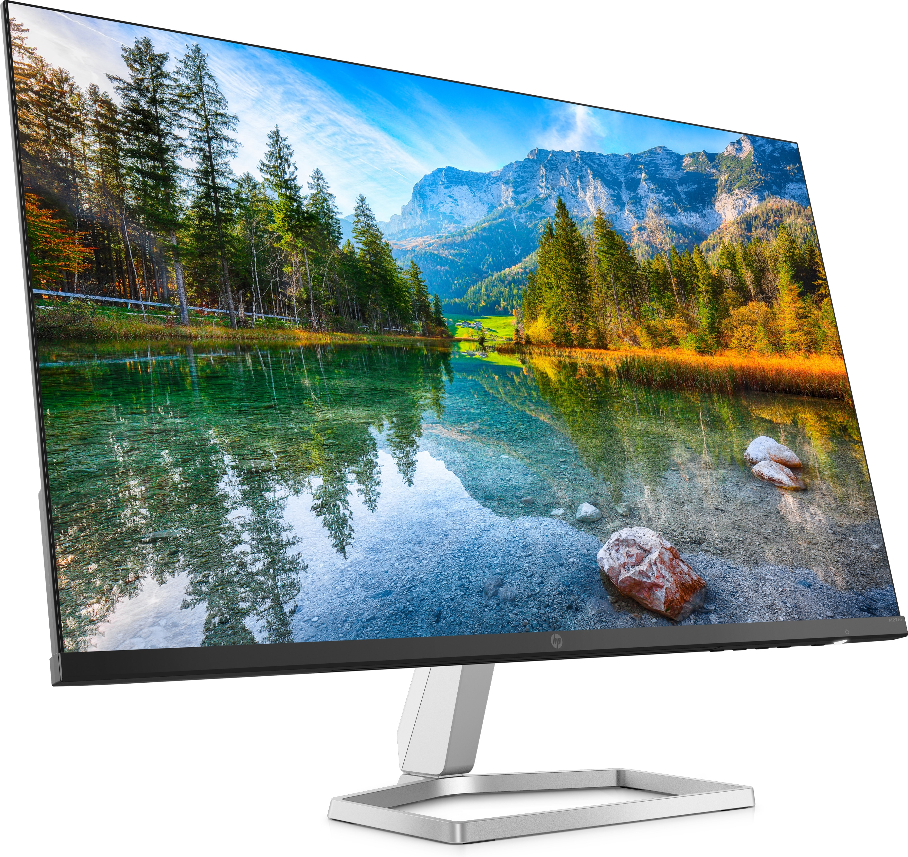 Monitor che mostra un paesaggio panoramico con montagne, lago e alberi sotto un cielo blu.