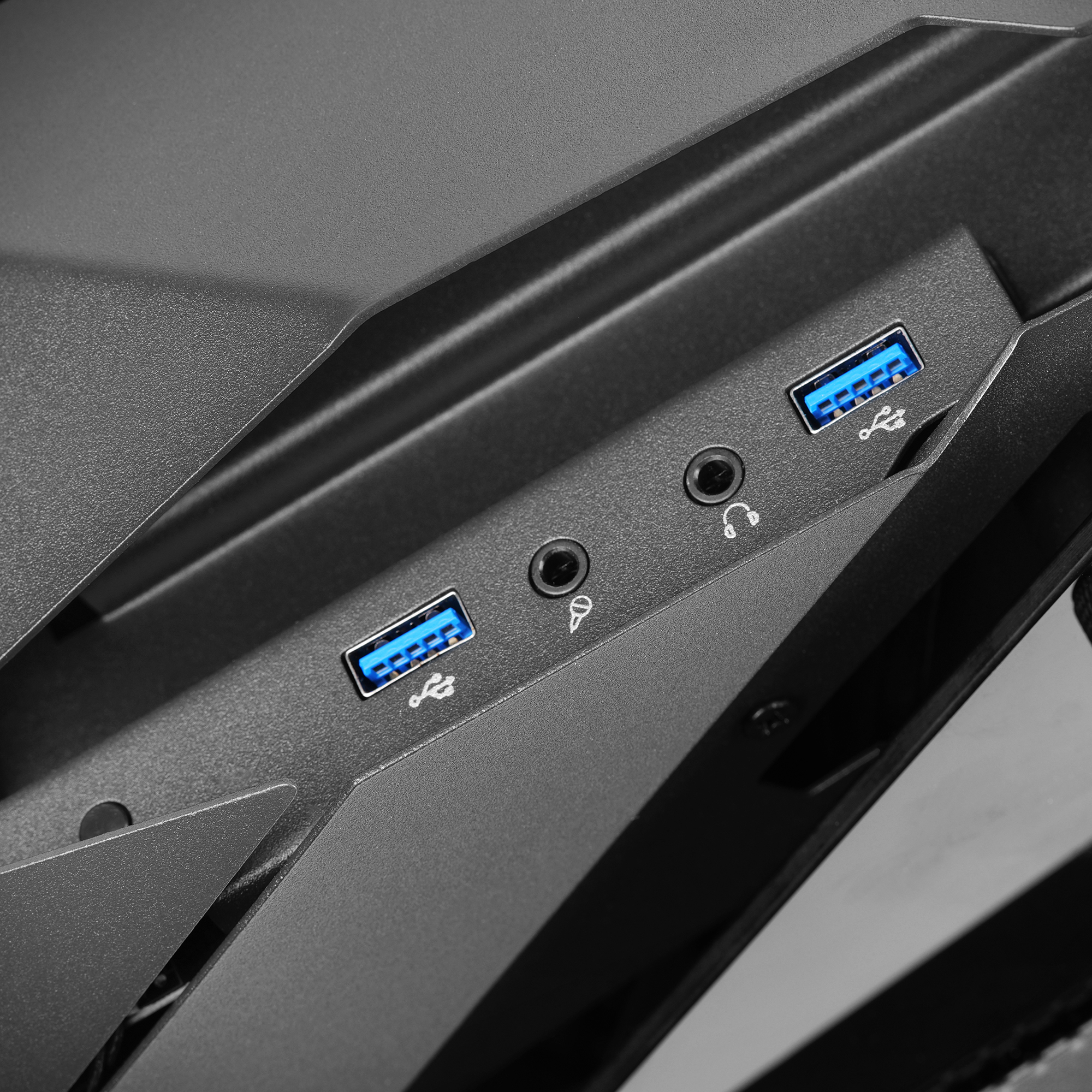 Zbliżenie portów czarnej obudowy komputera. Są porty USB i wejścia audio.