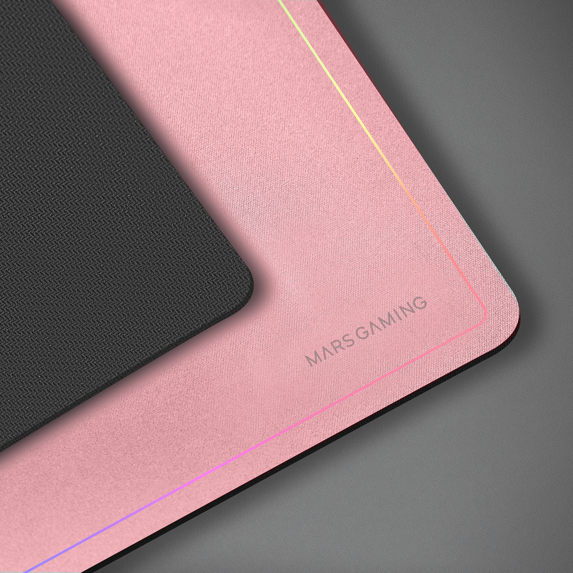 Różowa podkładka pod mysz dla graczy z czarnym obszarem, tekstem MARS GAMING i kolorowym podświetleniem na szarej powierzchni.