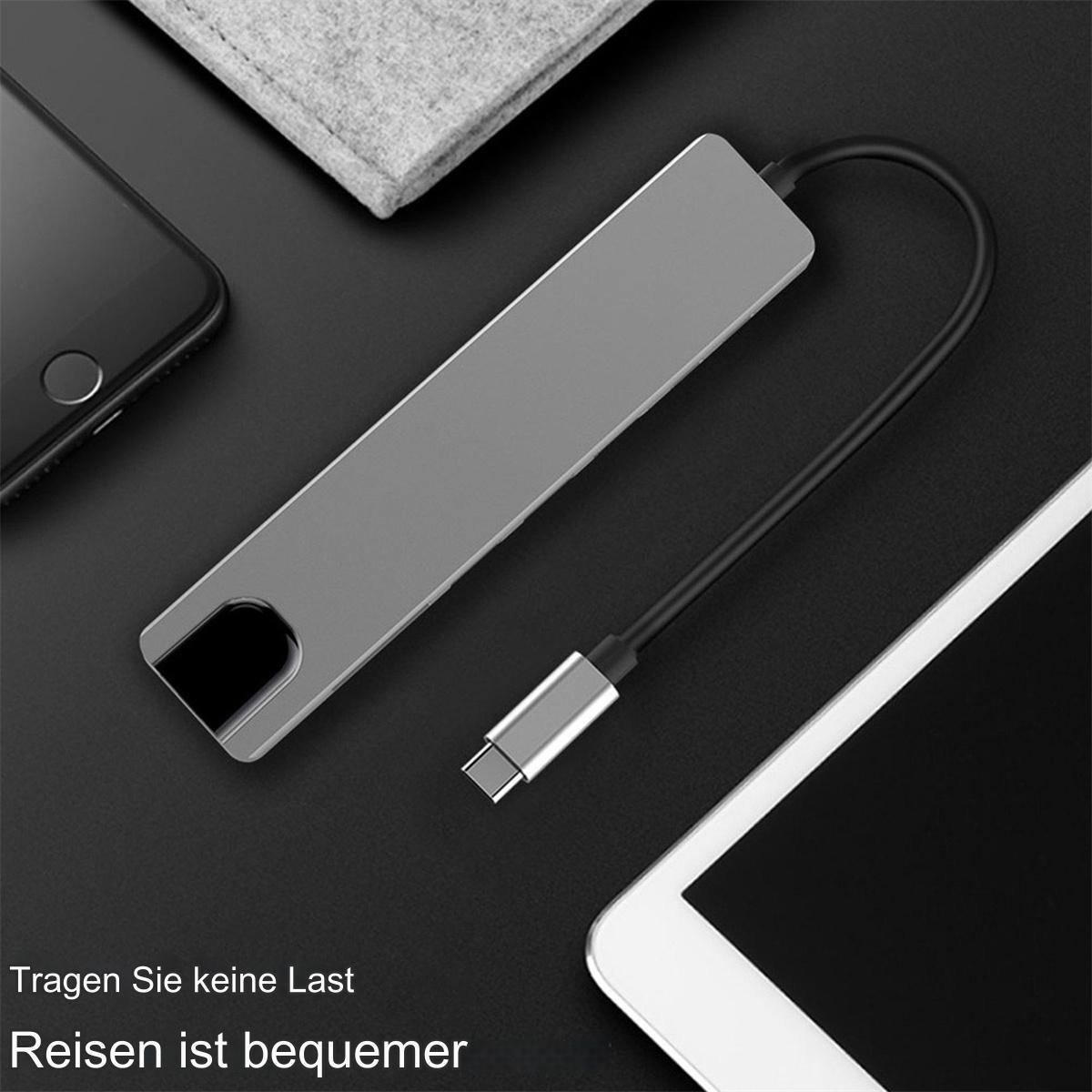 Ein silberner USB-C-Hub mit schwarzem Kabel und USB-C-Anschluss. Neben einem Telefon und Tablet.