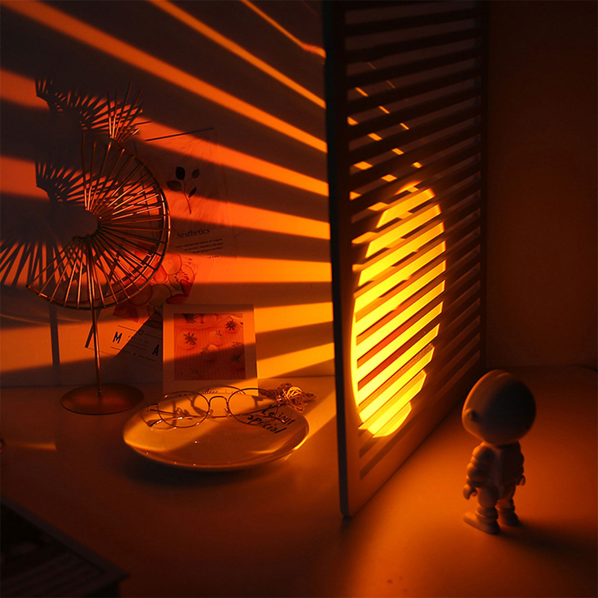 Ein Raum mit einem goldenen Ventilator, einer dekorativen Lampe, einem Teller und einer kleinen Figur.