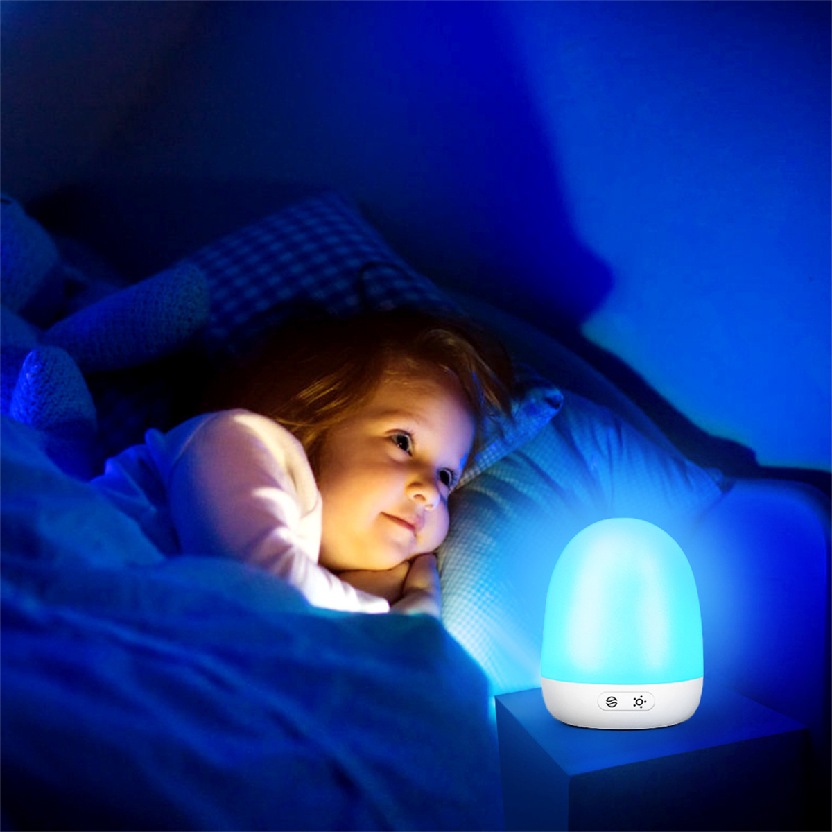 Kind im Bett mit Nachtlicht. Das Licht ist blau. Das Kind lächelt.