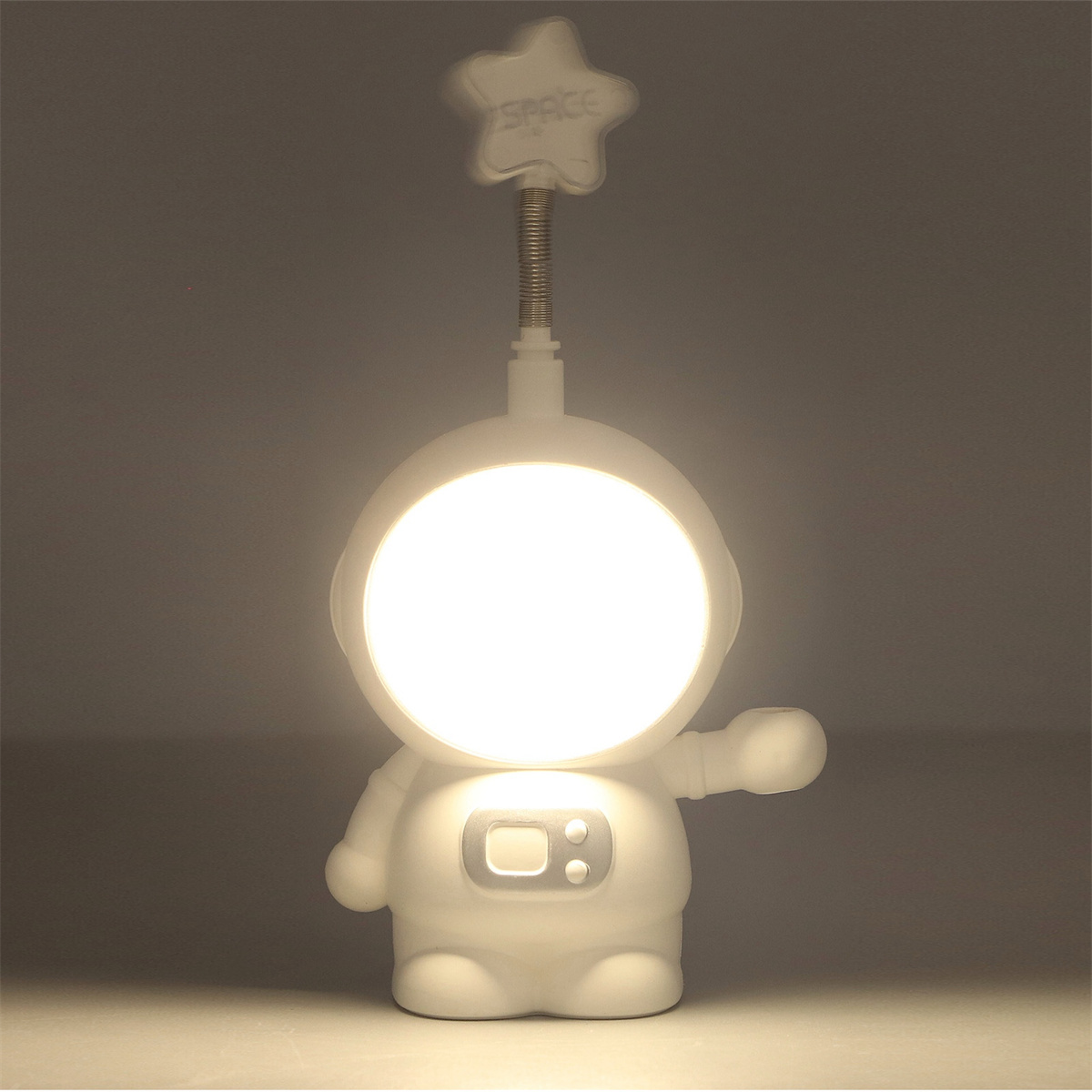 Eine Astronautenlampe mit weißem Körper und sternförmigem Licht. Das Licht ist an.