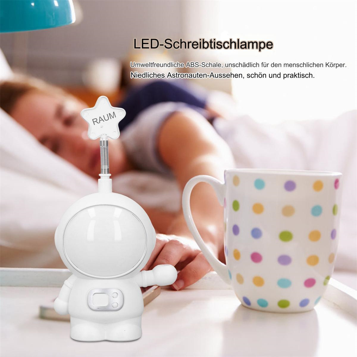 Weiße Astronautenlampe neben einer Tasse mit Tupfen. Eine Person schläft im Hintergrund.