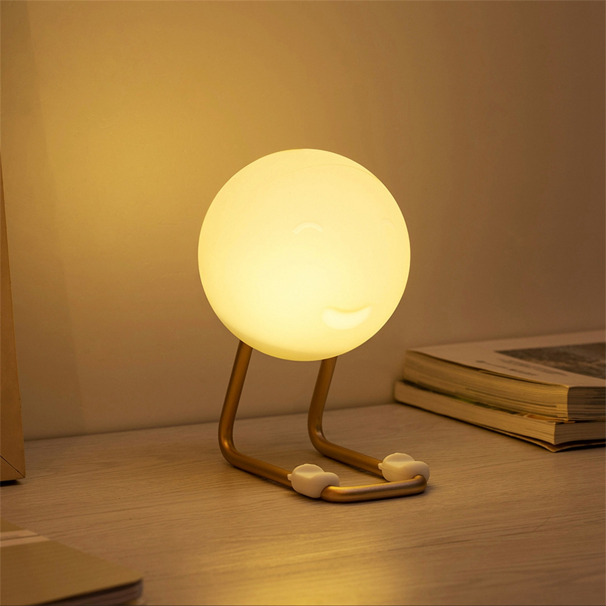 Tischlampe mit rundem Licht und geschwungenem Ständer. Sie steht auf einem Holztisch.