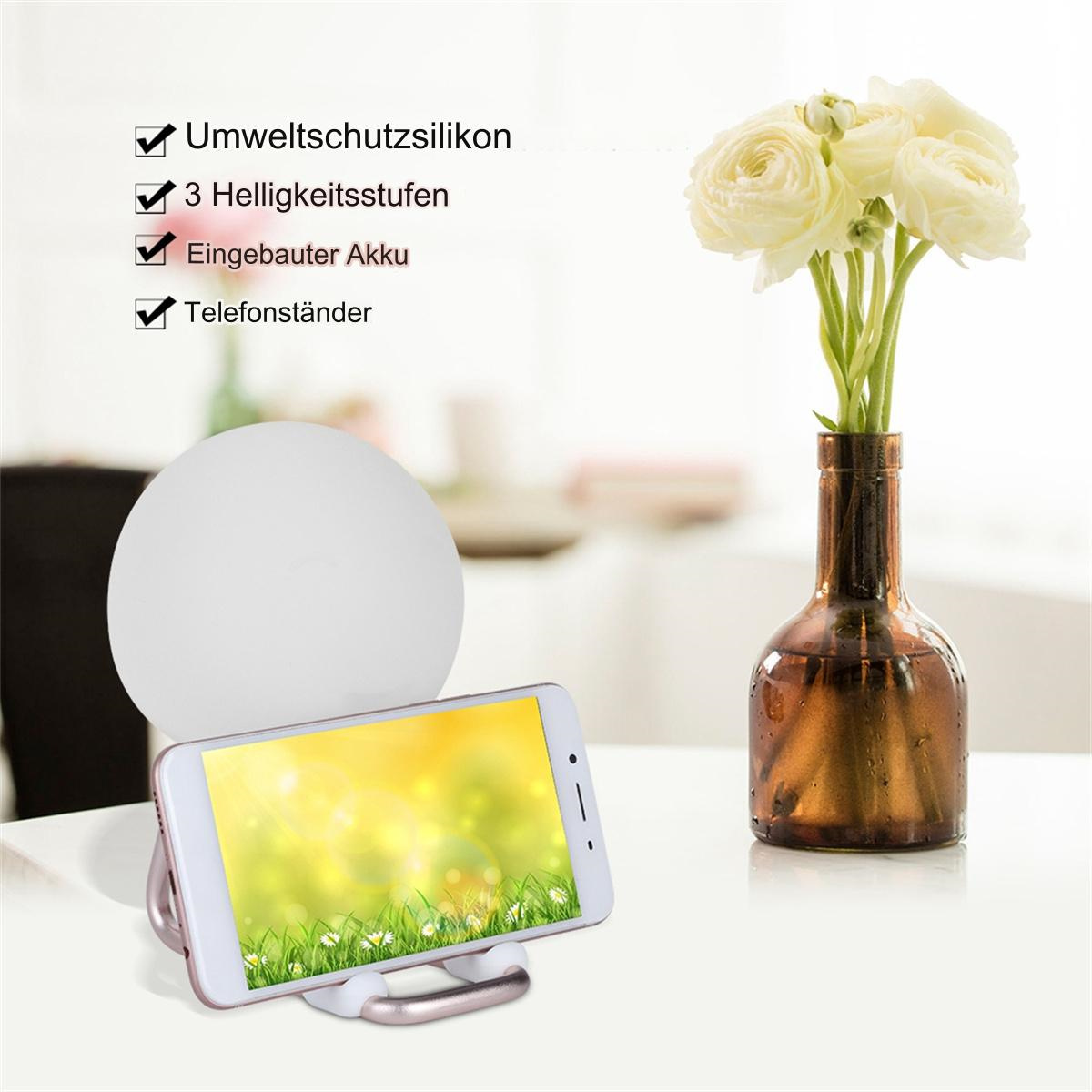 Telefon auf Ständer mit Blumen in Vase, und Text. Weißer Tisch, weißer Hintergrund.