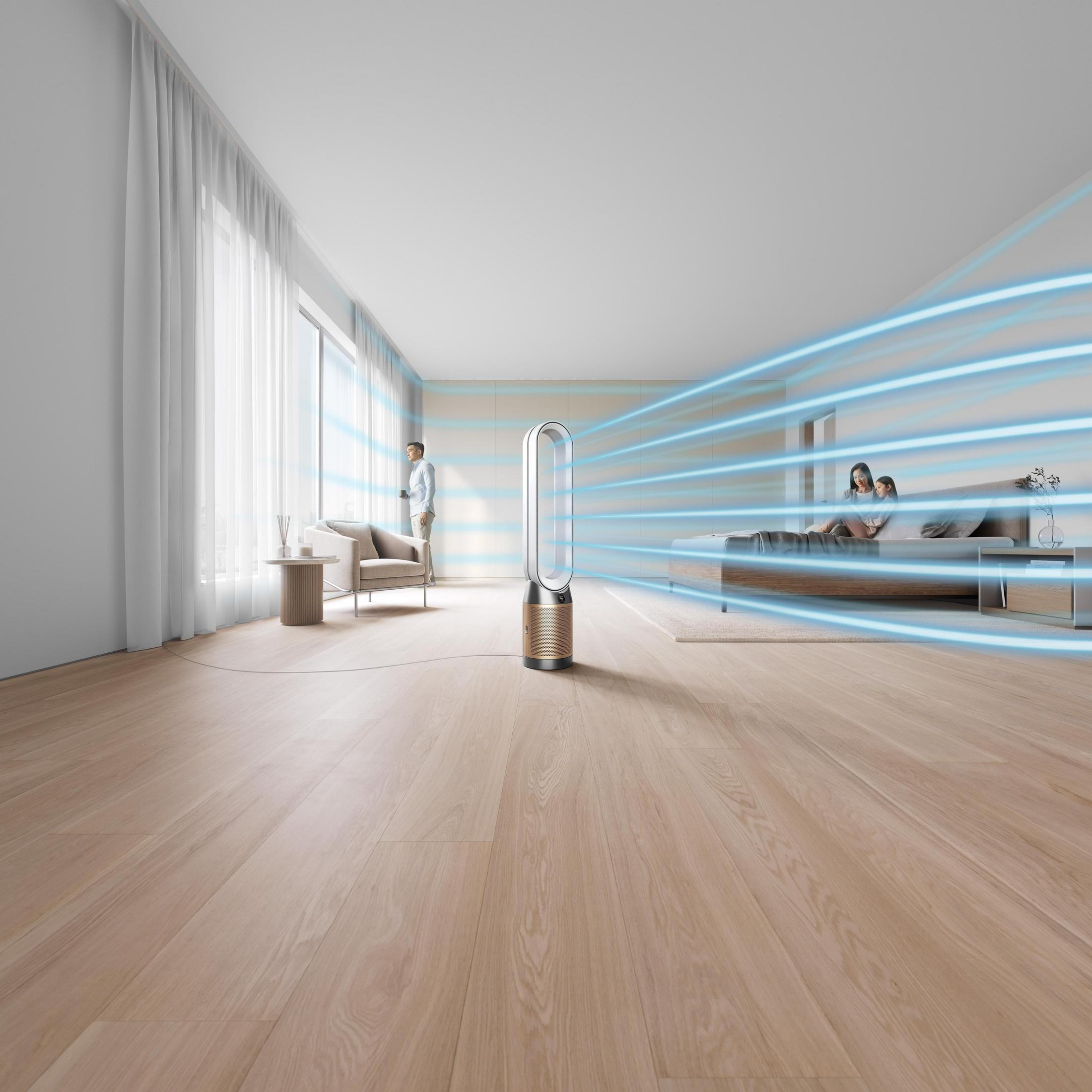 Ein moderner Ventilator ist in einem Raum eingeschaltet. Zwei Personen sind im Hintergrund, ein Mann am Fenster.