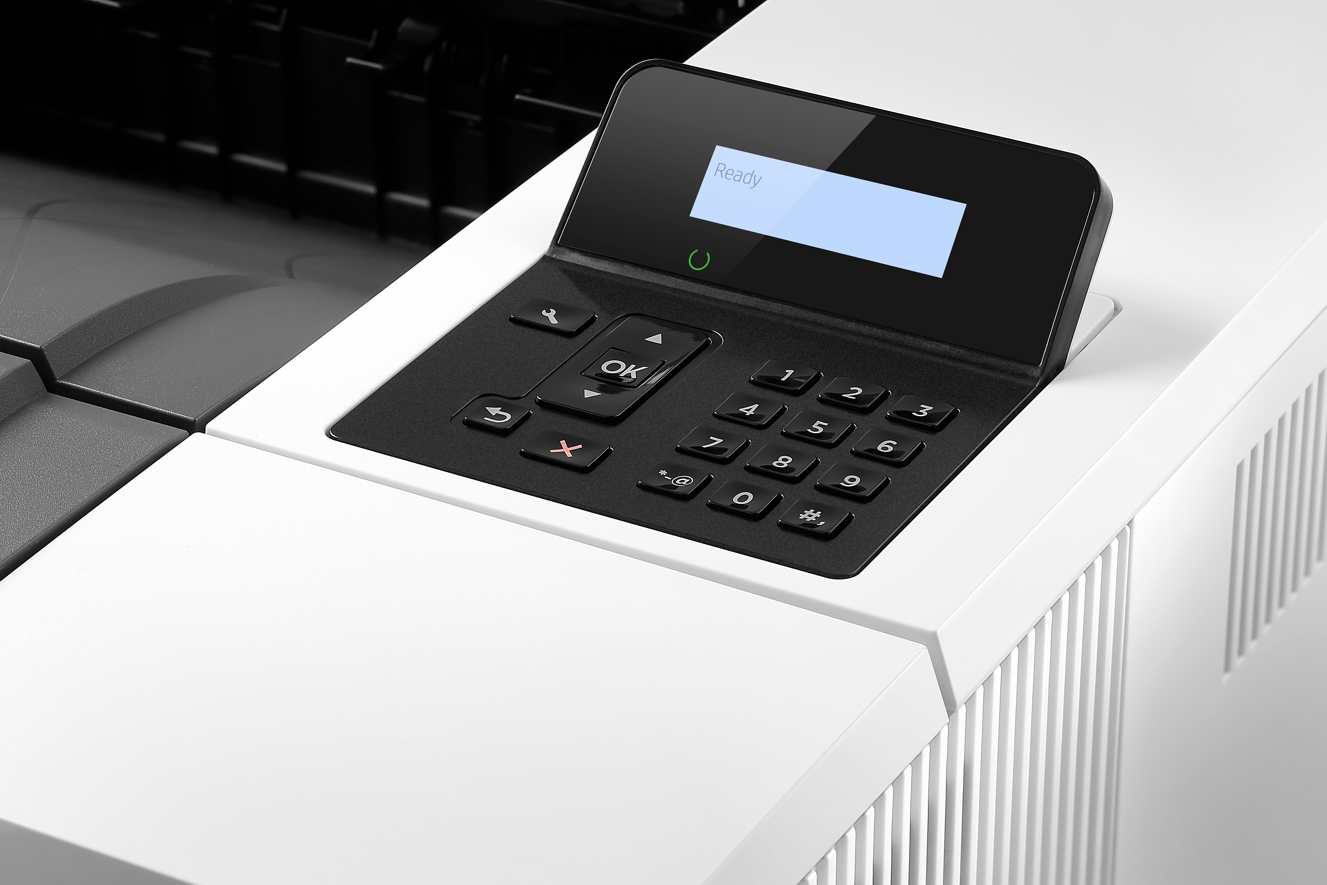 Panel sterowania drukarki z ekranem z napisem 'Gotowy' i kilkoma przyciskami. Jest czarny.