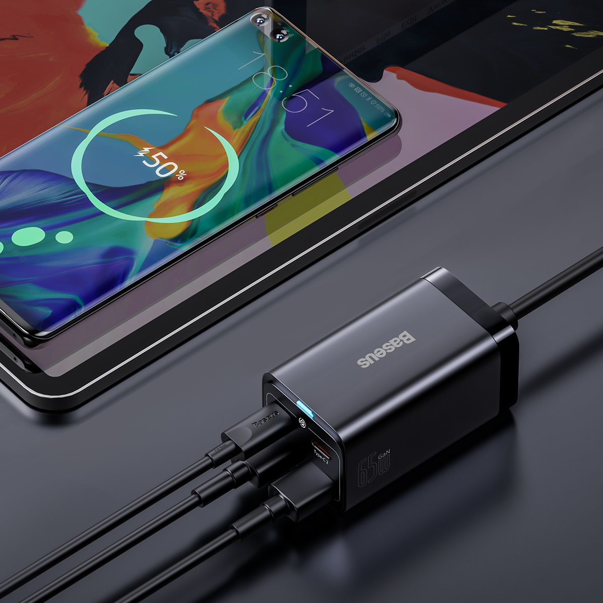 Station de charge noire avec trois câbles connectés à une tablette et un téléphone.