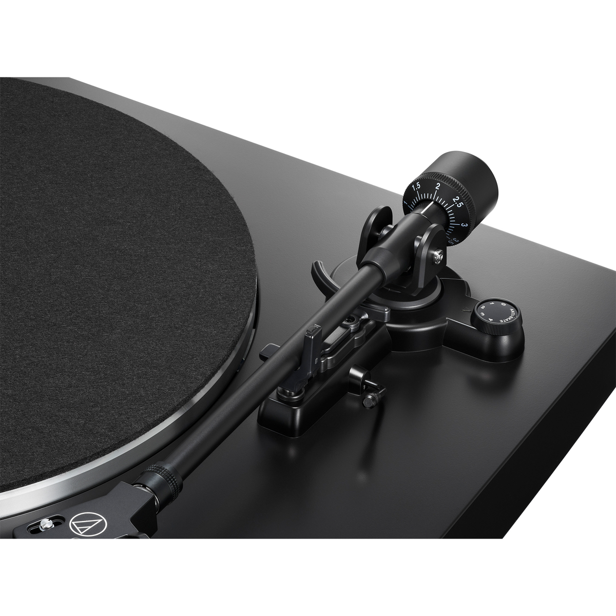 Tocadiscos negro con brazo y cápsula. El disco está a la izquierda. El brazo está en el centro.