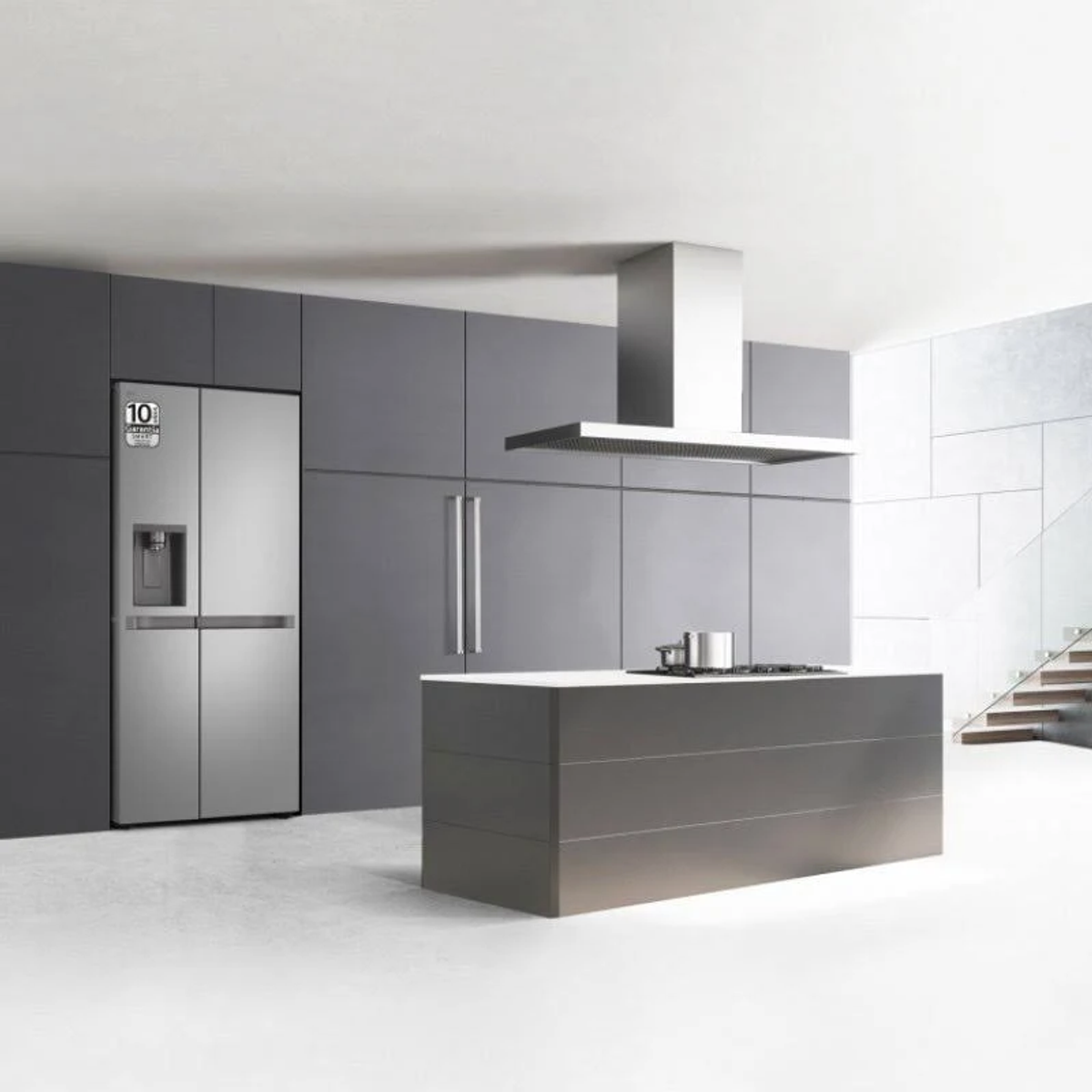 Cucina moderna con frigorifero. Elettrodomestici e armadi in acciaio inossidabile. Isola e scale visibili.