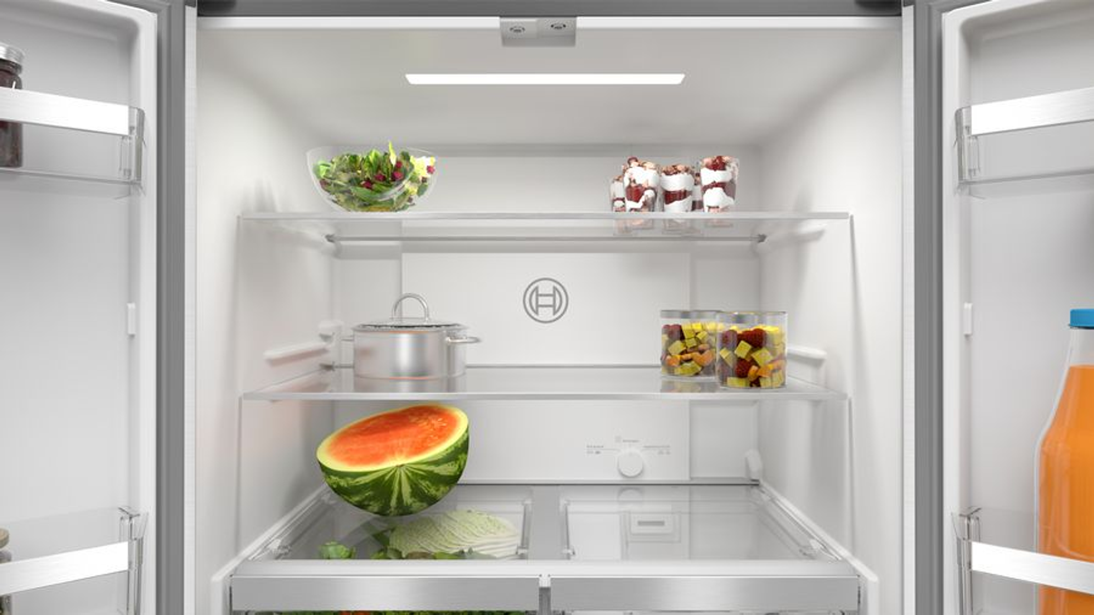 Wnętrze lodówki. Zawiera półki z jedzeniem, jak arbuz, sałatka i słoiki.
