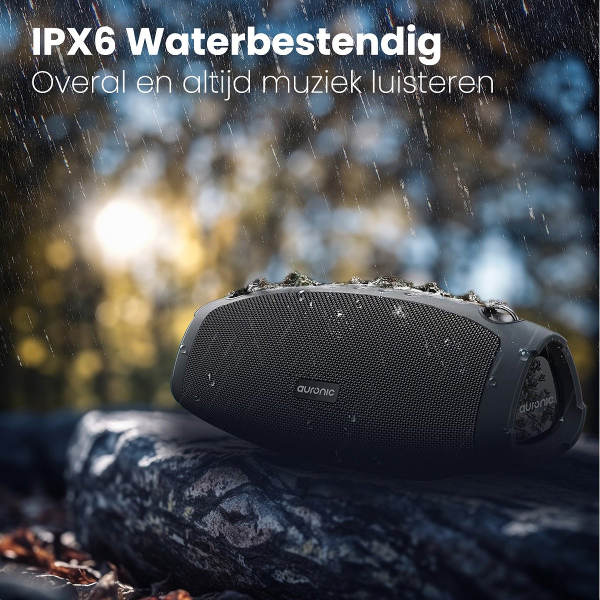 Zwarte luidspreker op een boomstam, met waterdruppels. Achtergrond is wazig, zonnig en groen.