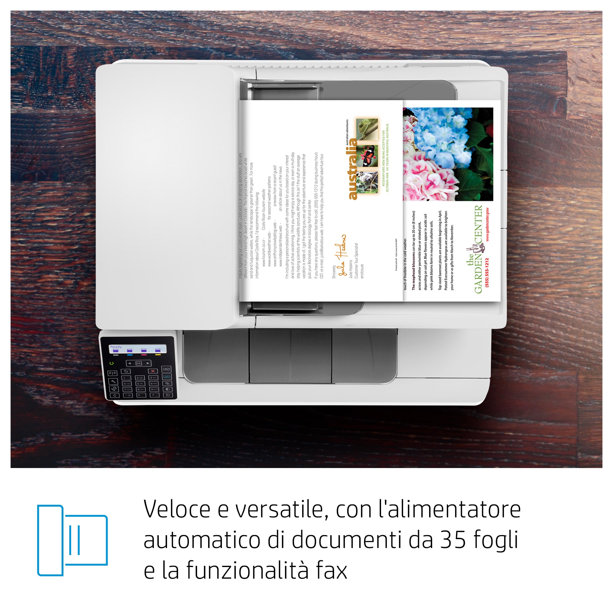 Una vista aérea de una impresora imprimiendo un documento con imágenes de flores y texto. Está sobre madera.