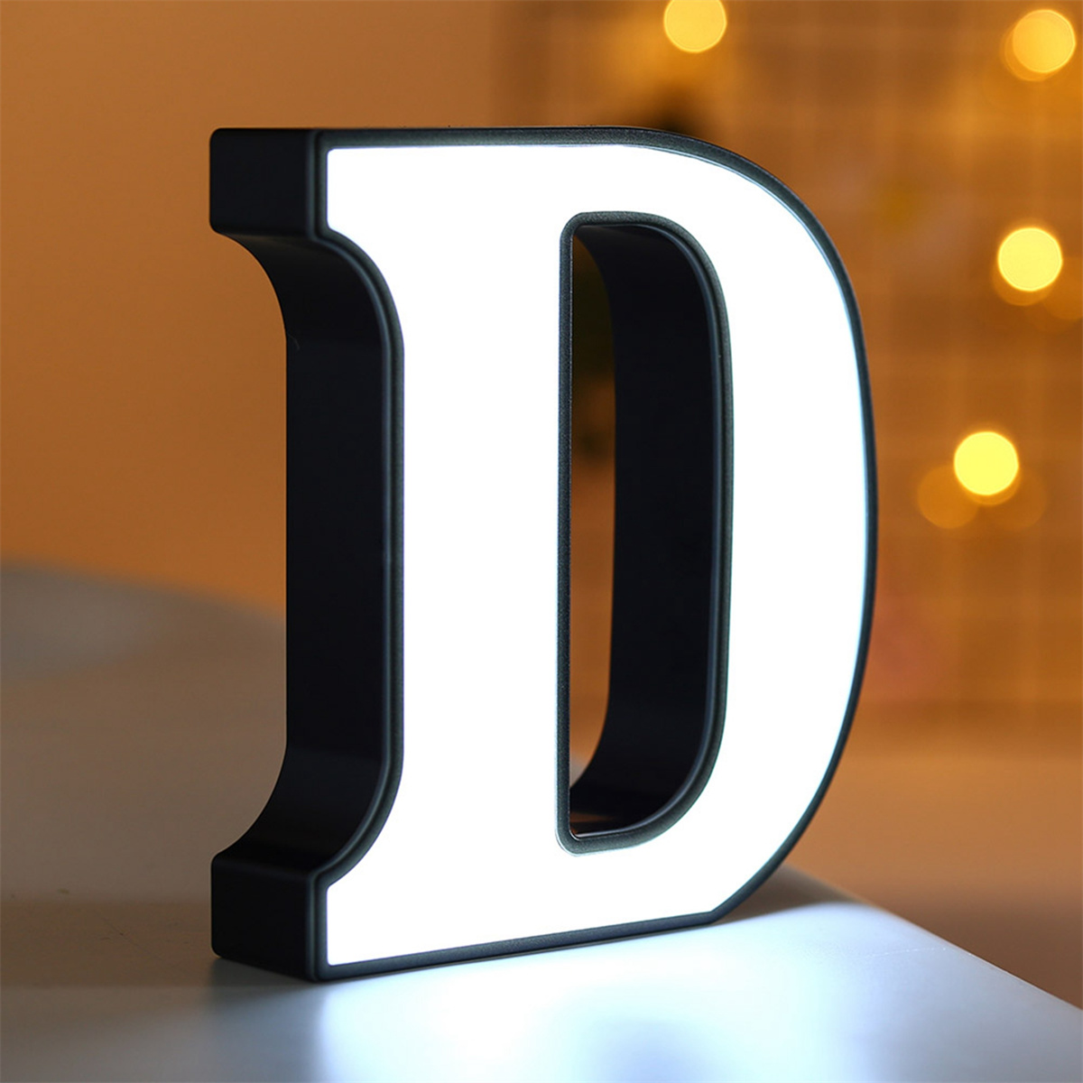 Ein beleuchteter Buchstabe D mit schwarzem Rahmen.