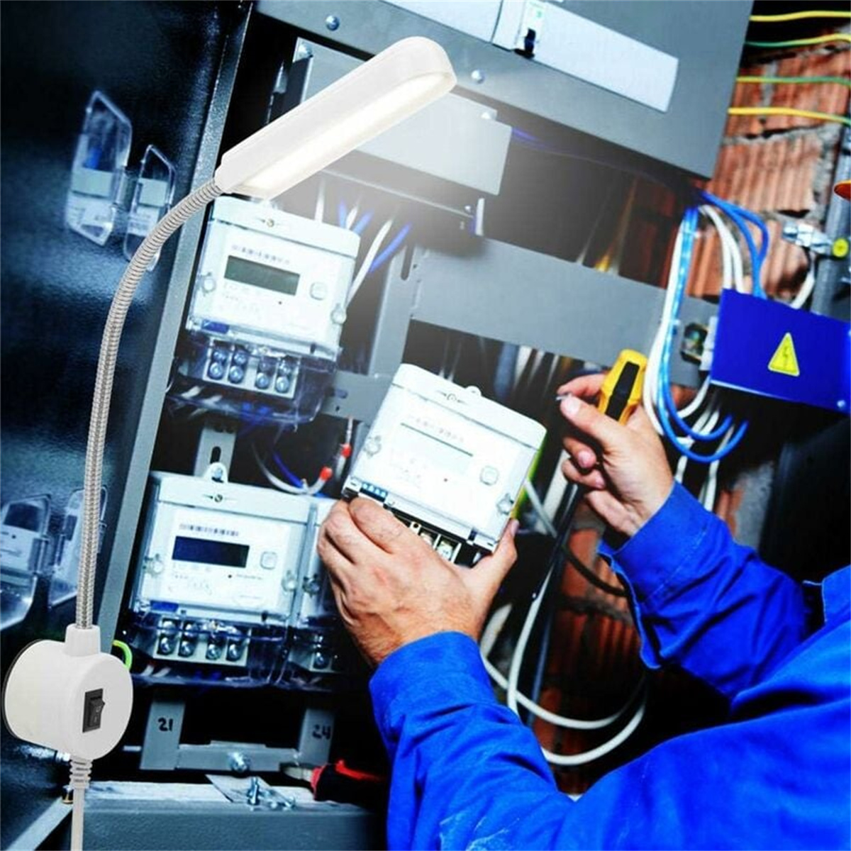 Eine flexible Lampe beleuchtet eine Schalttafel. Eine Person arbeitet an der Tafel.