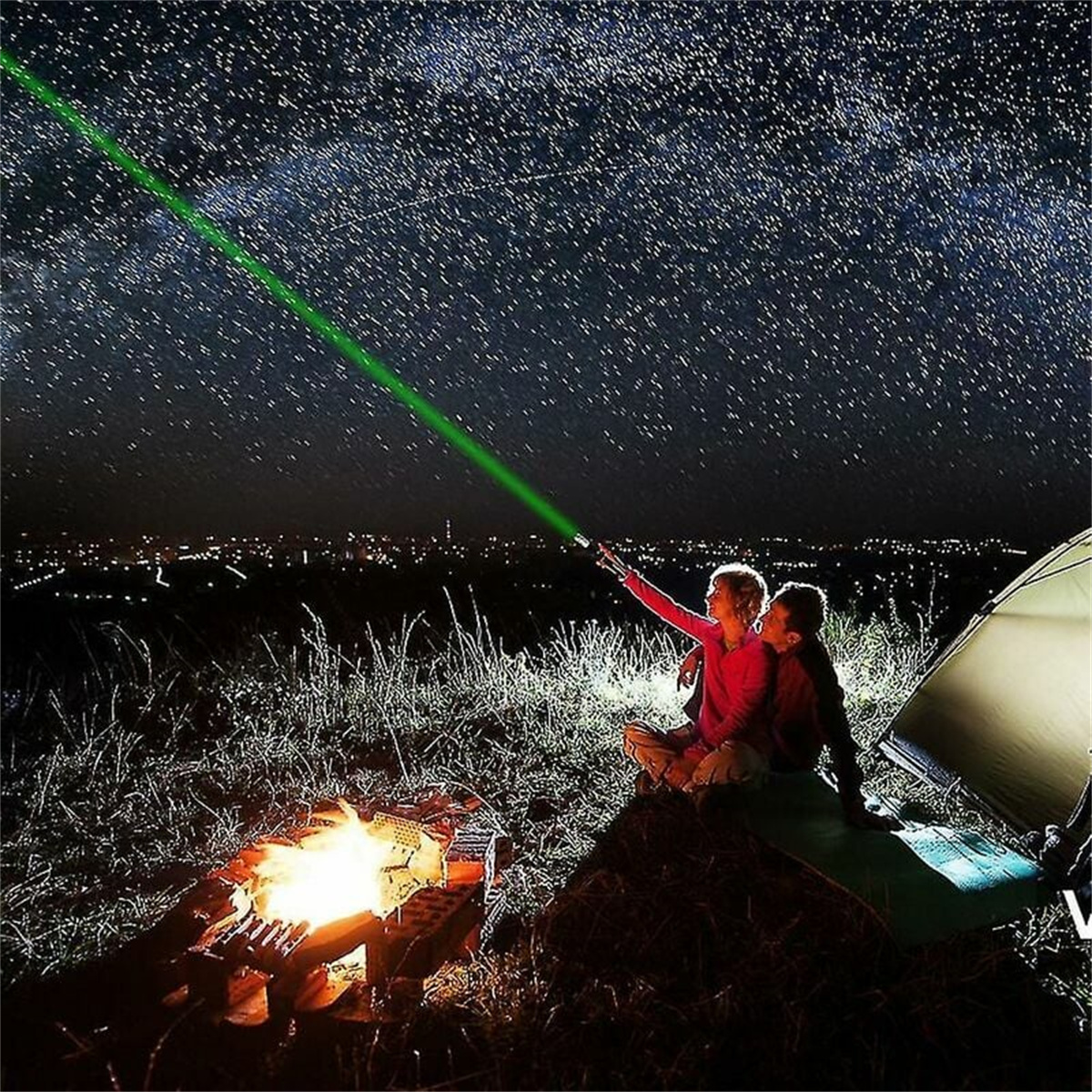 Zwei Personen zeigen mit einem Laser auf die Sterne. Lagerfeuer und Zelt sind im Hintergrund.