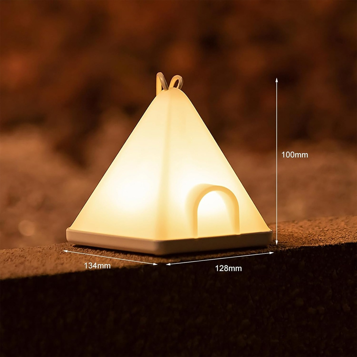 Eine kleine zeltförmige Lampe, die gelb leuchtet, mit den Maßen: 134 mm x 128 mm x 100 mm.