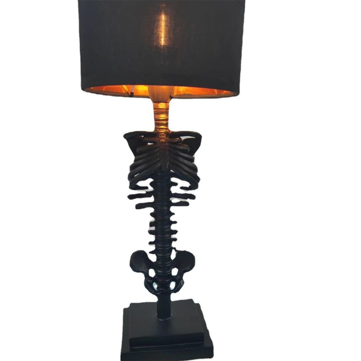 Eine schwarze Skelettlampe mit schwarzem Schirm und goldenem Innenraum. Der Hintergrund ist weiß.