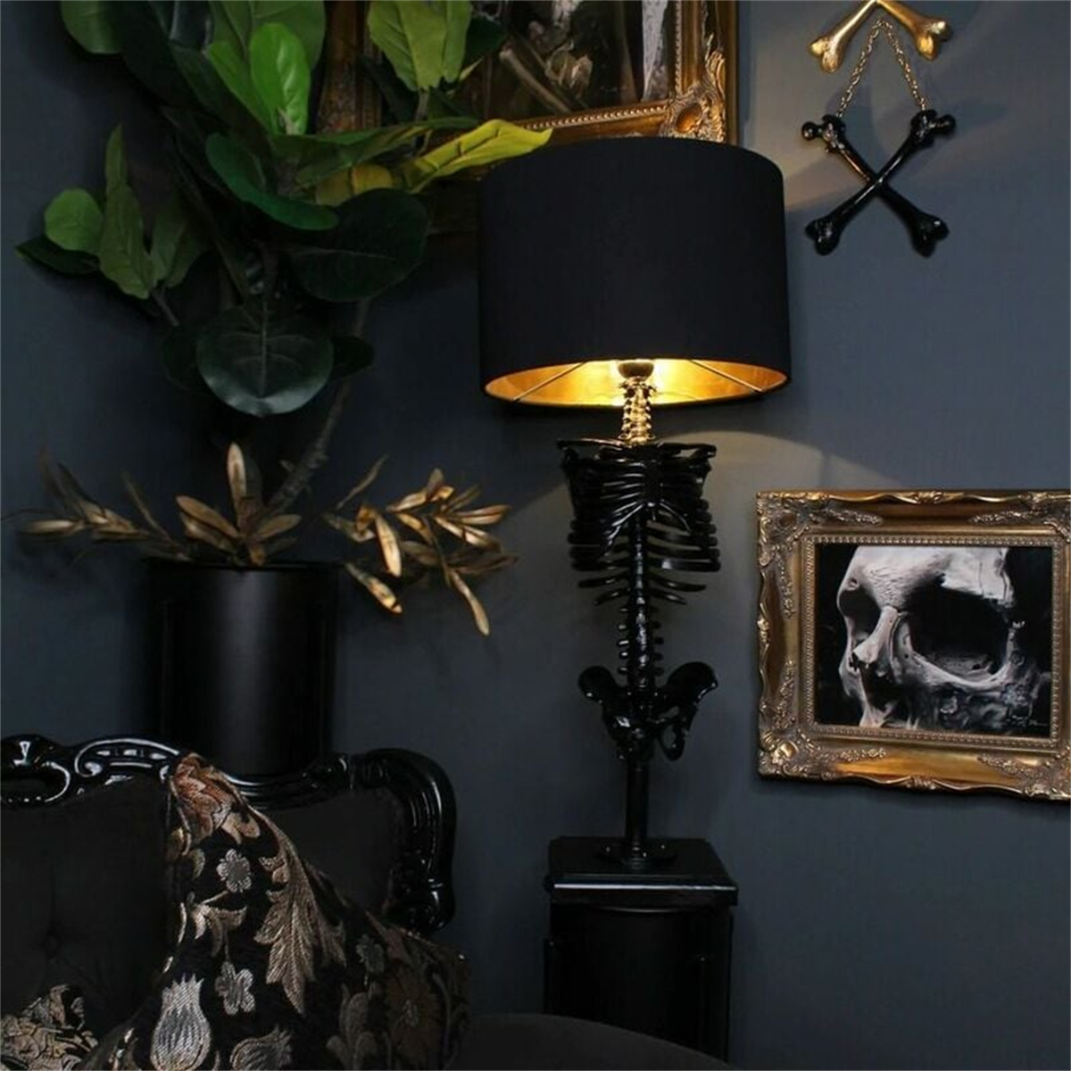 Eine schwarze Skelettlampe mit schwarzem Lampenschirm und Totenkopfbild an der Wand.
