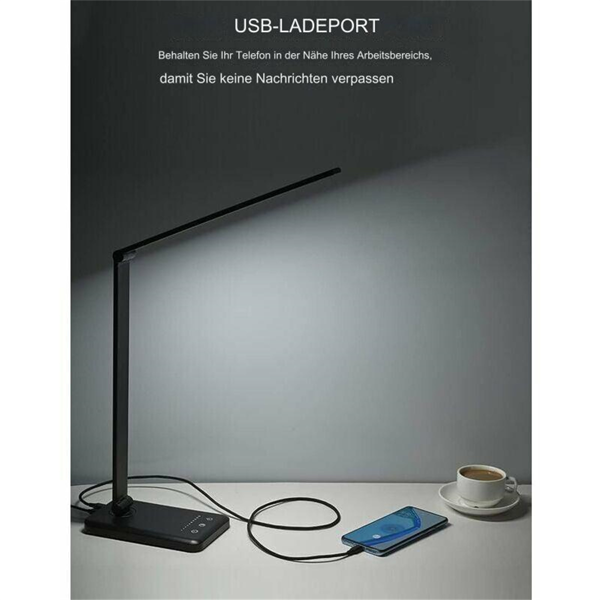 Eine schwarze Schreibtischlampe mit Telefon und Kaffeetasse, USB-Aufladung.