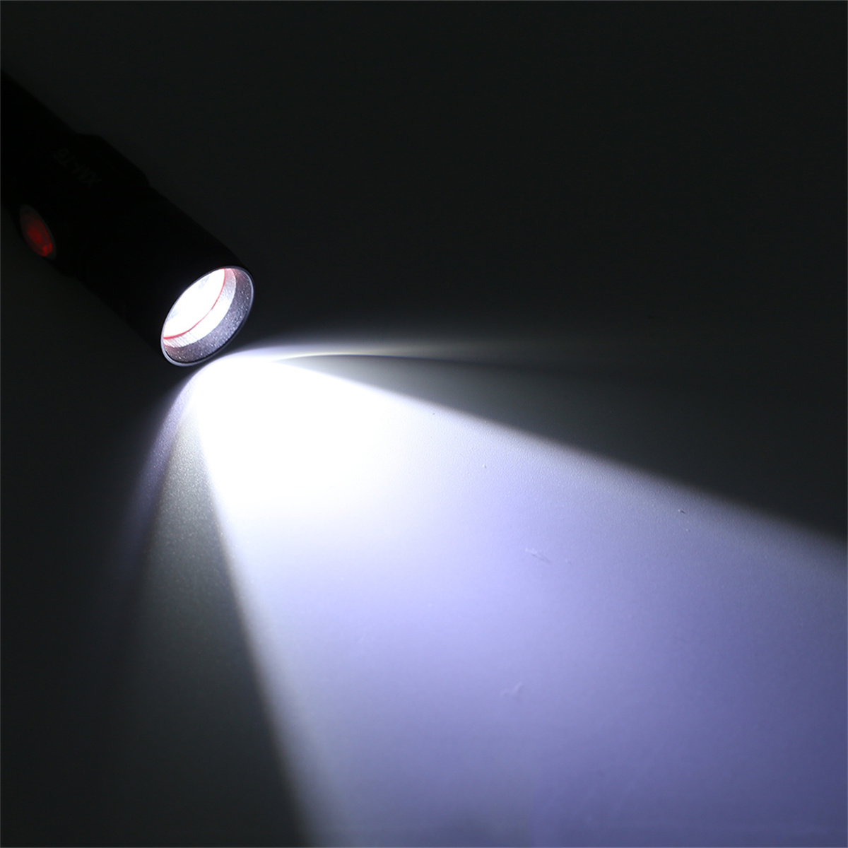 Ein Taschenlampenstrahl scheint auf eine Oberfläche. Das Licht ist weiß, der Hintergrund dunkel.