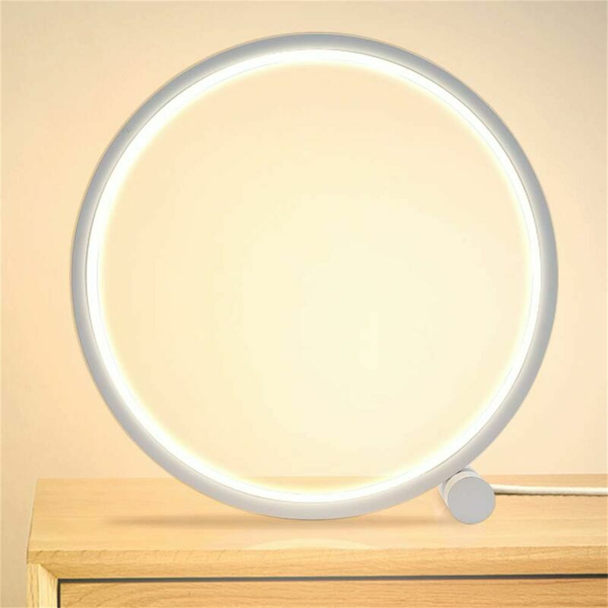 Runde, weiße LED-Lampe auf Holzoberfläche. Sie strahlt warmes, weiches Licht aus. Hellbrauner Hintergrund.