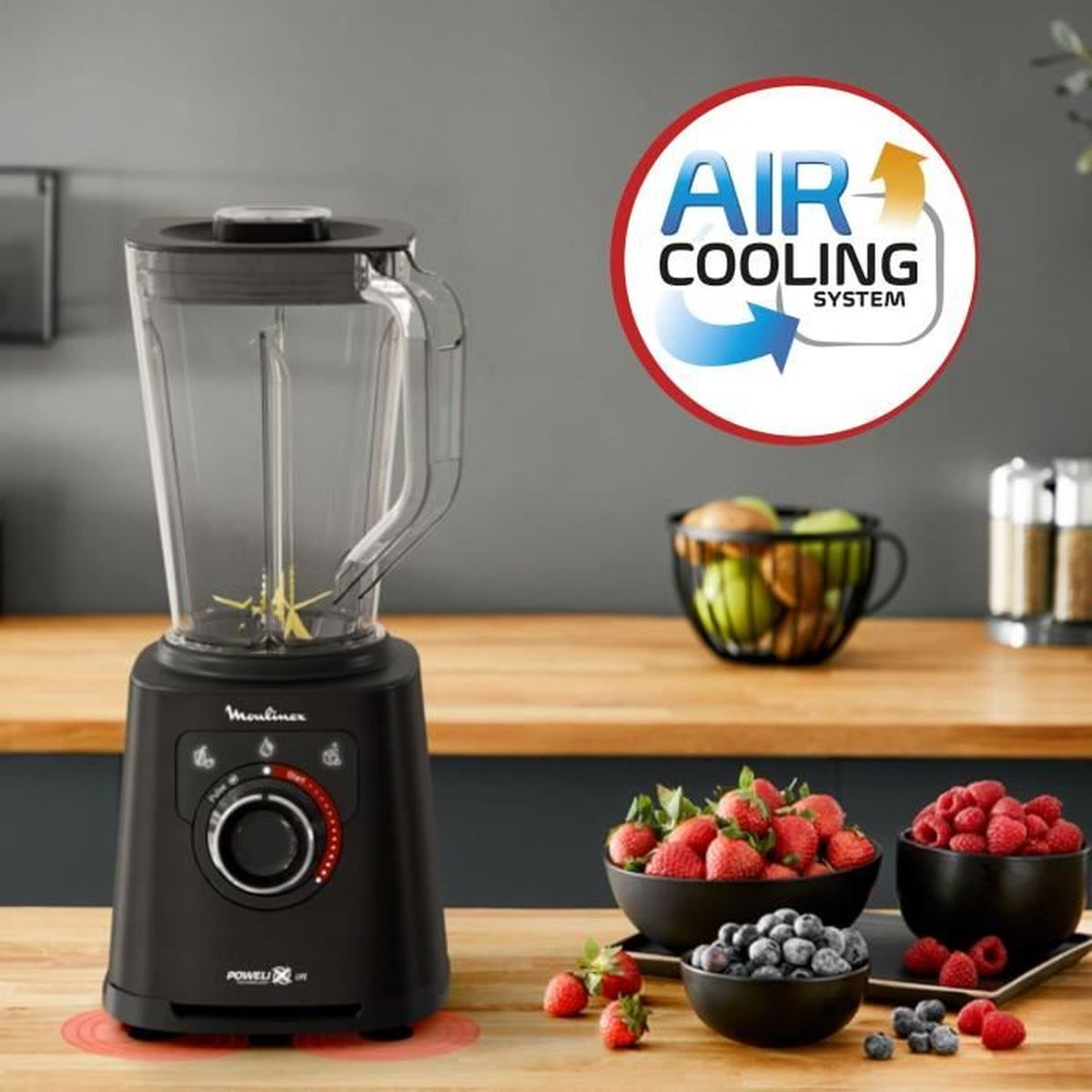 Licuadora negra con un recipiente de vidrio, frutas y un letrero que dice Air Cooling System.