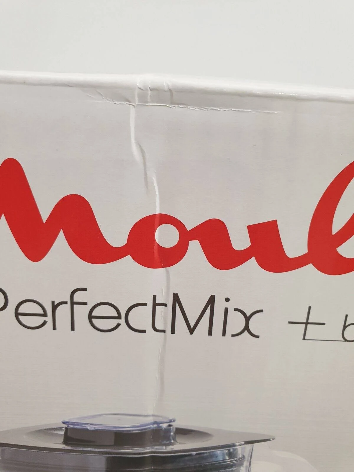 Primer plano de caja blanca con texto rojo 'Moulinex' y base de licuadora.