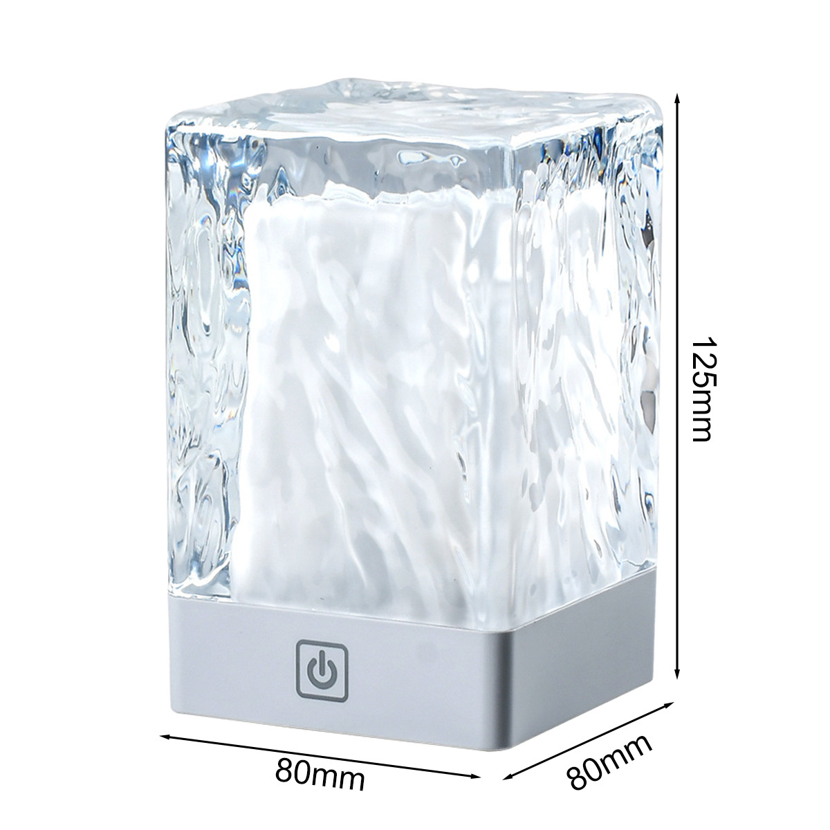 Eine transparente würfelförmige Lampe mit weißem Licht im Inneren. Graue Basis mit Ein-Aus-Taste.