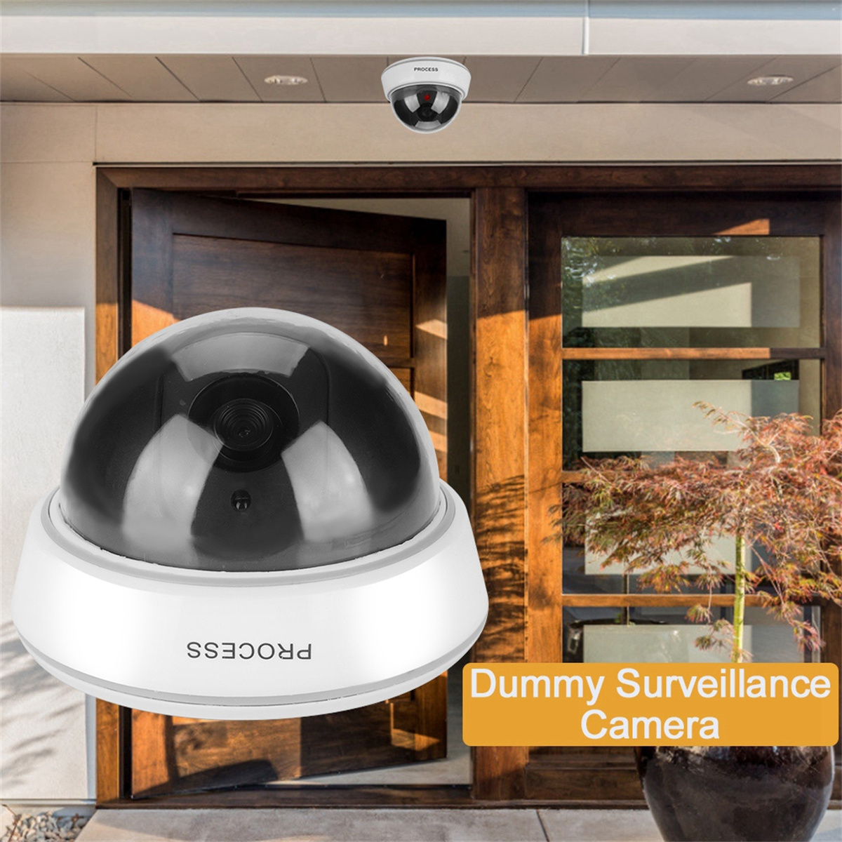Dummy-Überwachungskamera an einem Gebäude. Die Kamera ist weiß mit einer schwarzen Kuppel. Der Text lautet 'Dummy Surveillance Camera'.