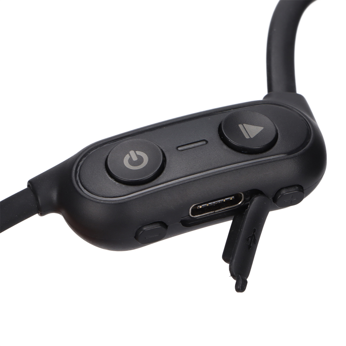 Schwarze Sport-Ohrhörer mit Knöpfen. USB-Anschluss offen. Der Hintergrund ist unscharf.
