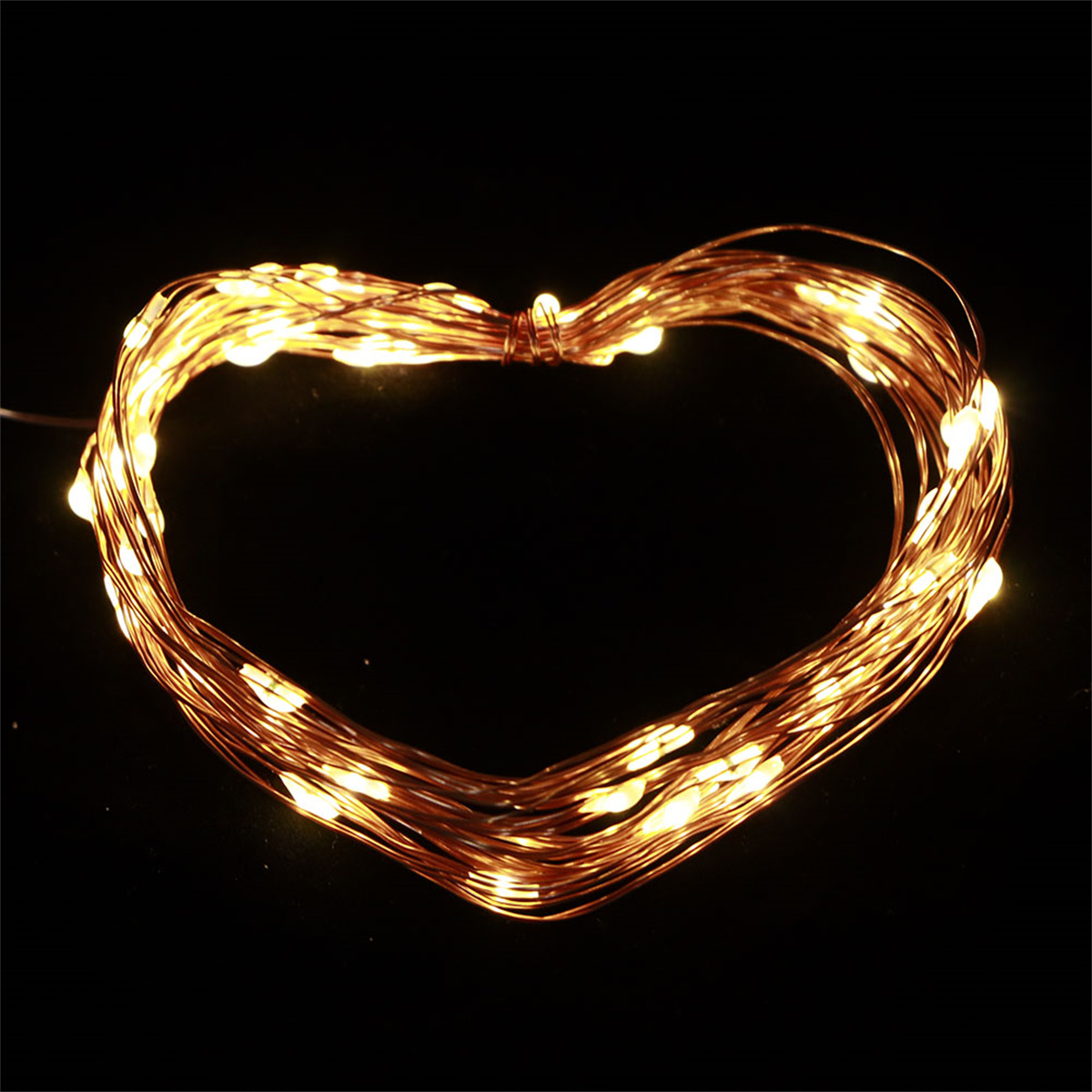 Lichterkette in Herzform, auf schwarzem Hintergrund beleuchtet.