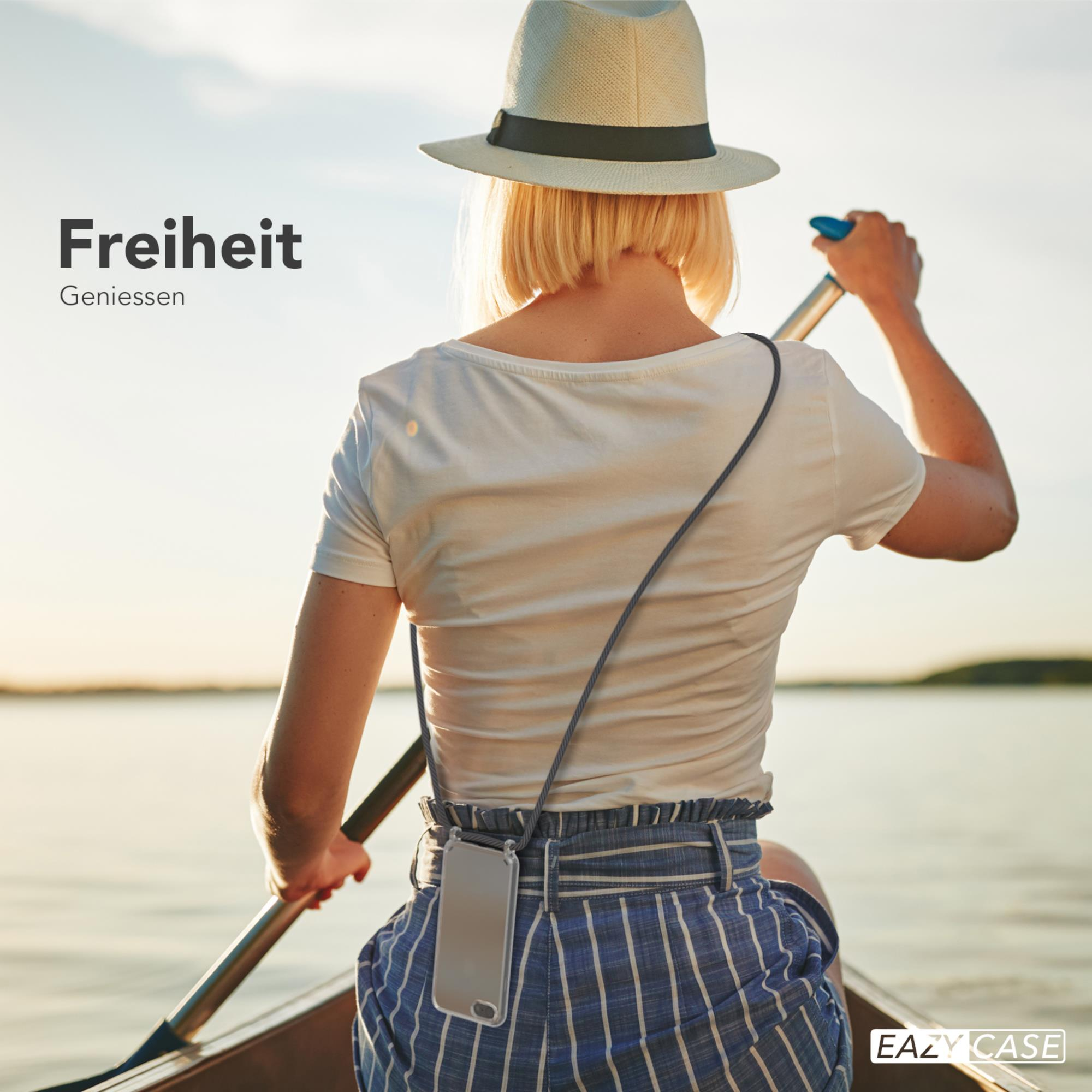 Eine Frau rudert in einem Boot auf einem See, trägt einen Hut und hält ein Ruder. Text: Freiheit. Geniessen.