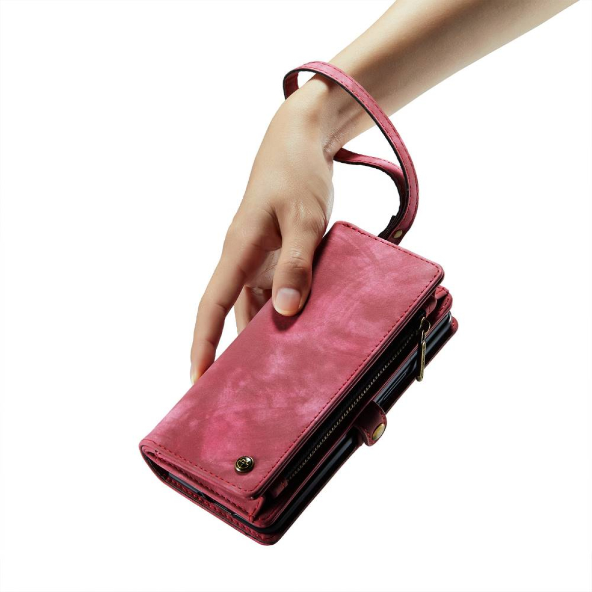 Eine Hand hält eine pinke Geldbörse. Sie hat eine Handschlaufe und einen Reißverschluss.