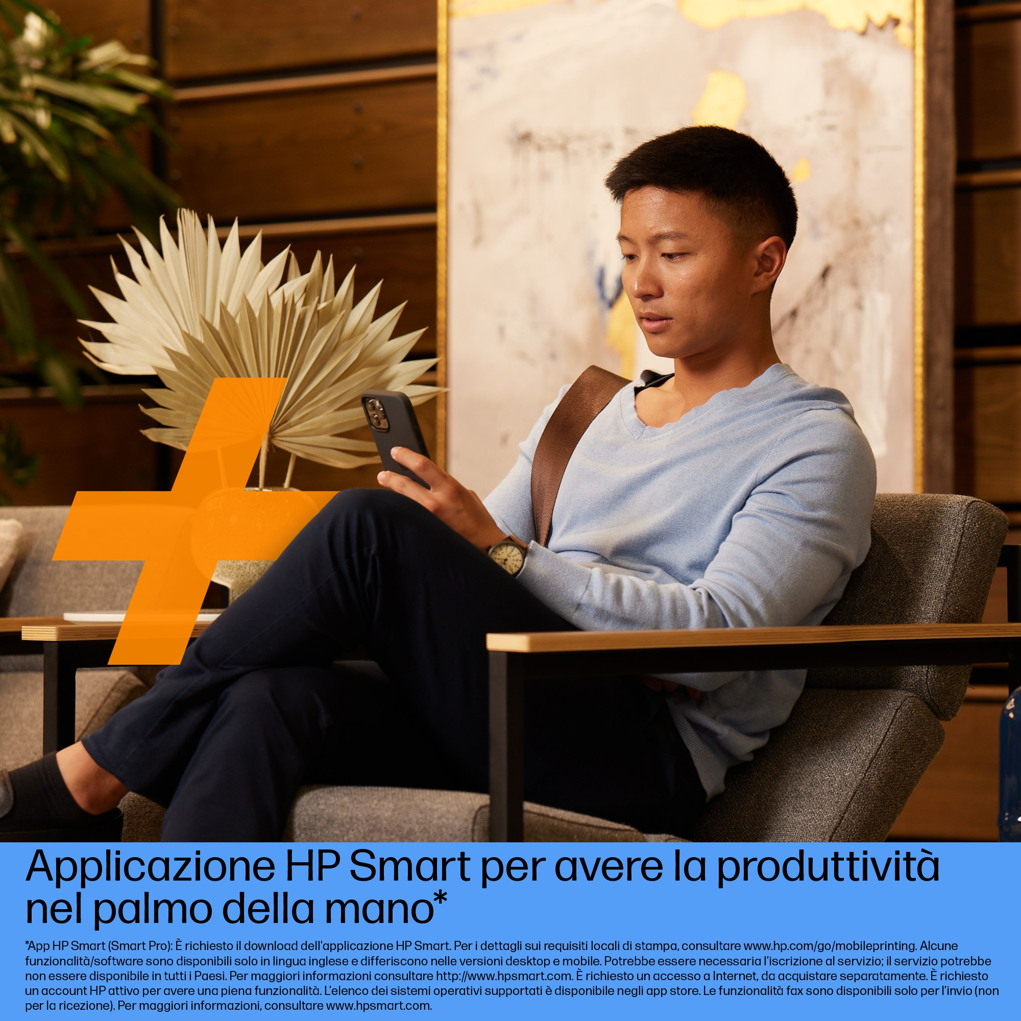 Un uomo seduto, usa uno smartphone. Un grande segno più arancione sullo sfondo.