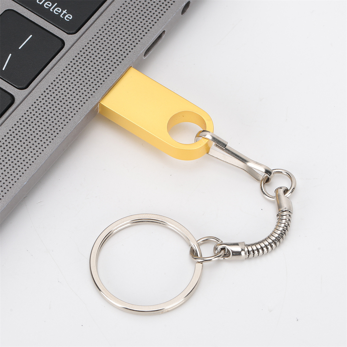 Goldener USB-Stick mit silberner Kette und Schlüsselring.