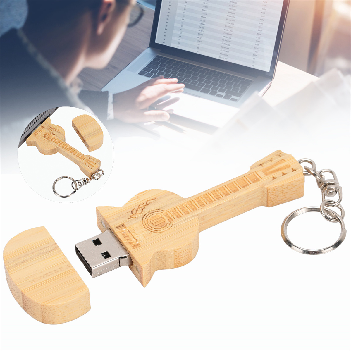 Gitarrenförmiger USB-Stick aus Holz mit Schlüsselanhänger, offenem Deckel und Laptop im Hintergrund.