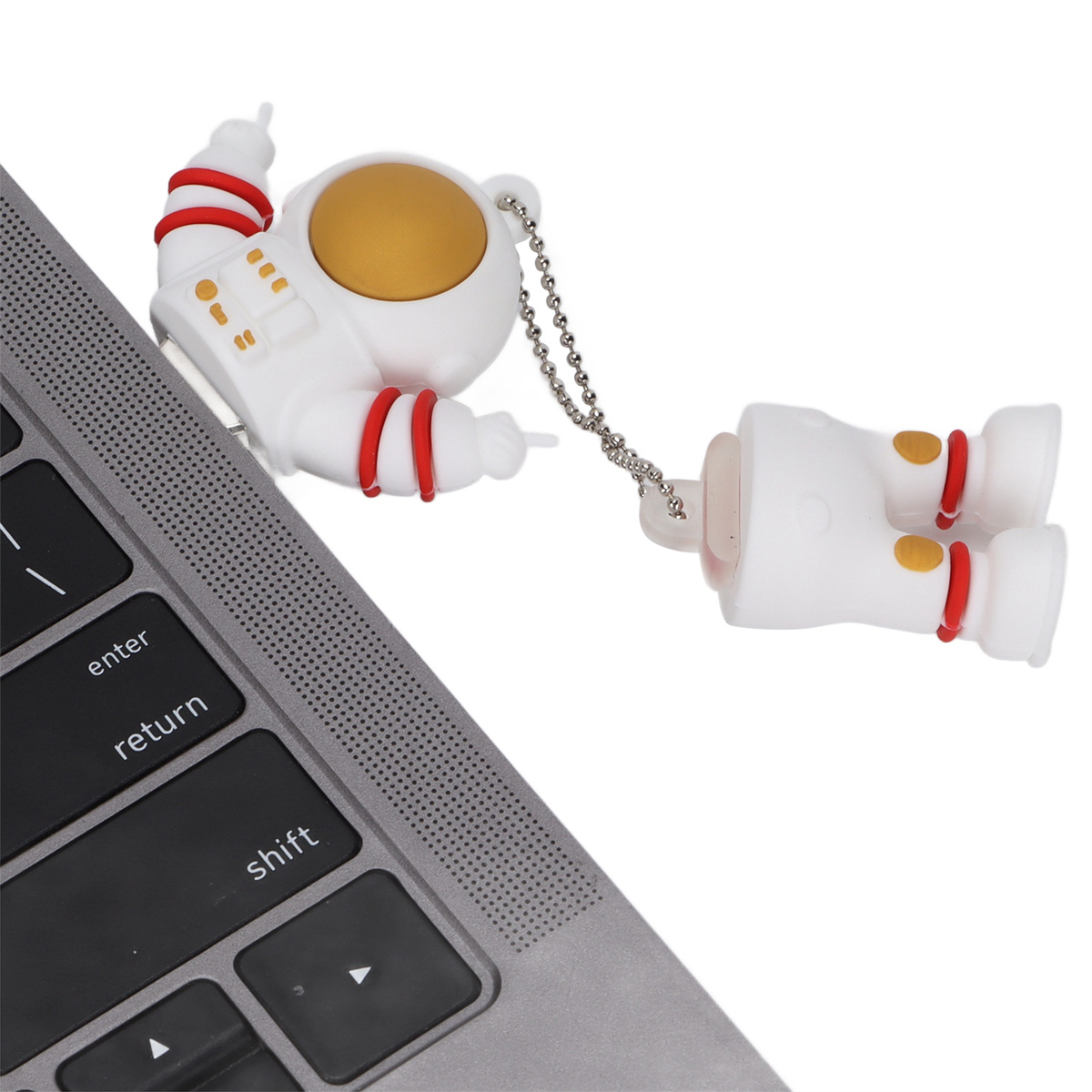 Weißer Astronauten-USB-Stick, an einen Laptop angeschlossen. Der Astronaut ist zweiteilig, mit einer Kette.
