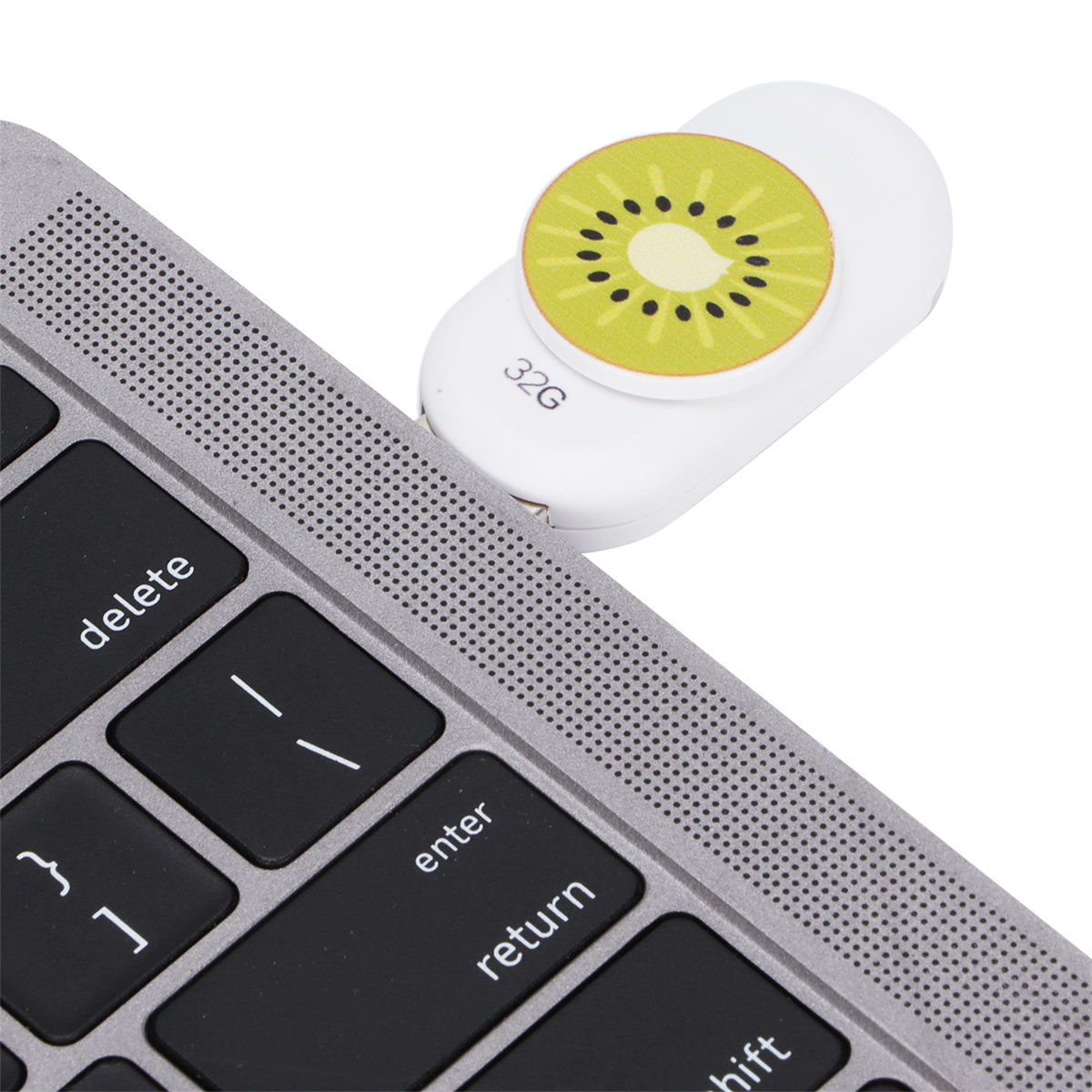 Laptop-Tastatur mit einem USB-Stick in Kiwi-Form. Die Tasten sind schwarz und grau.