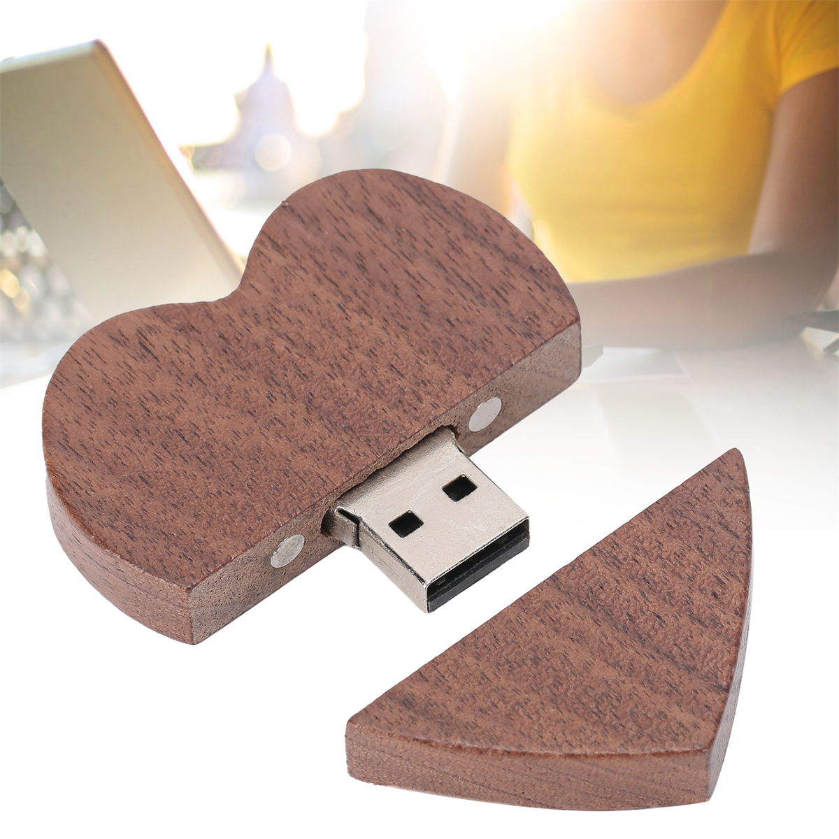 Herzförmiger USB-Stick aus Holz mit einem separaten Stück. Es hat eine dunkle Holzoberfläche.