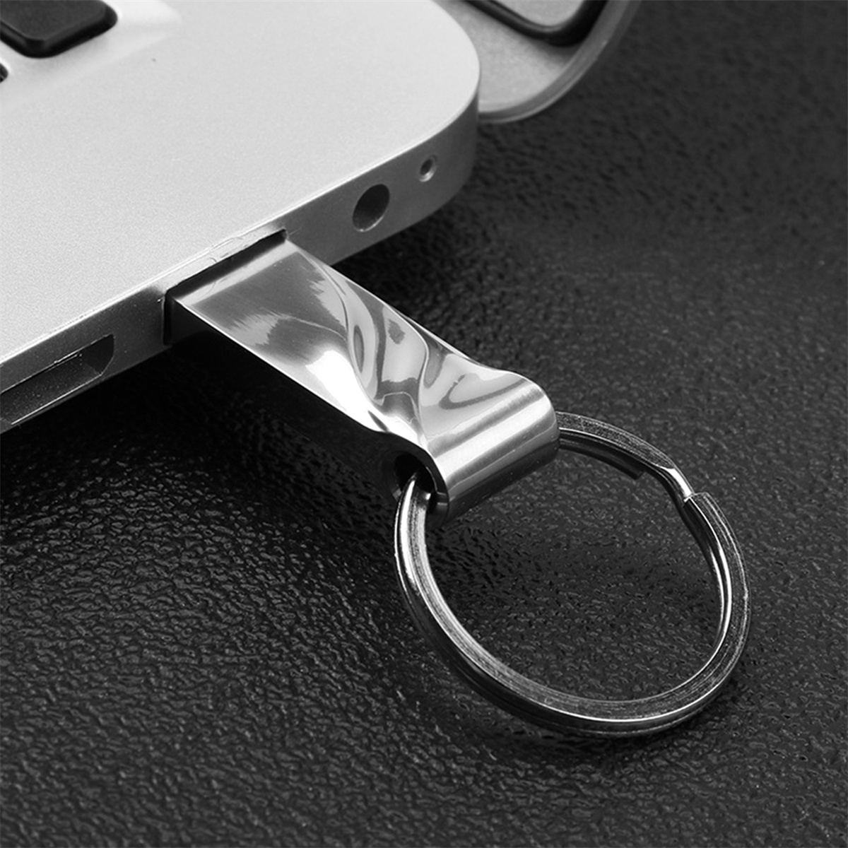 Ein silberner USB-Stick, der an einen Laptop angeschlossen ist.